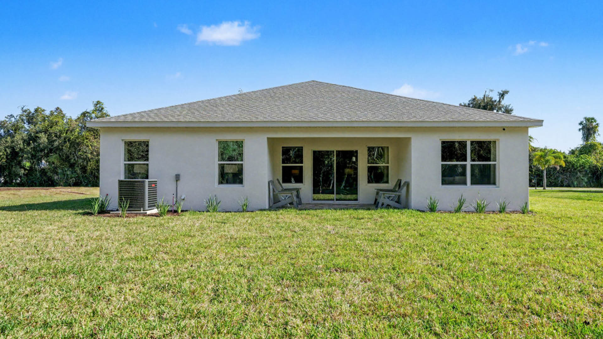 A spacious home surrounded by a large grassy yard, showcasing a well-maintained outdoor area.