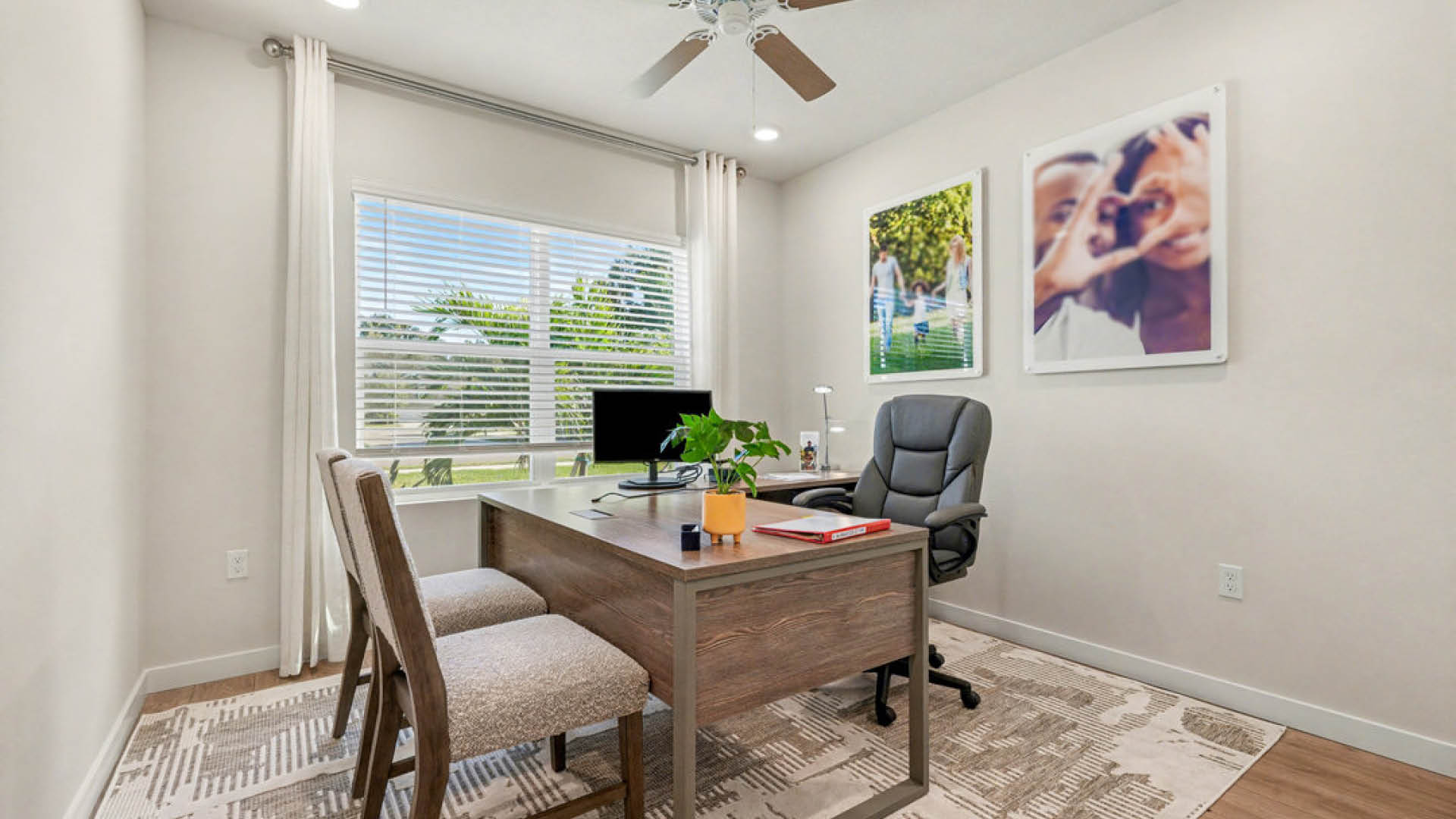 A home office featuring a desk, chair, and a ceiling fan, creating a comfortable workspace environment.