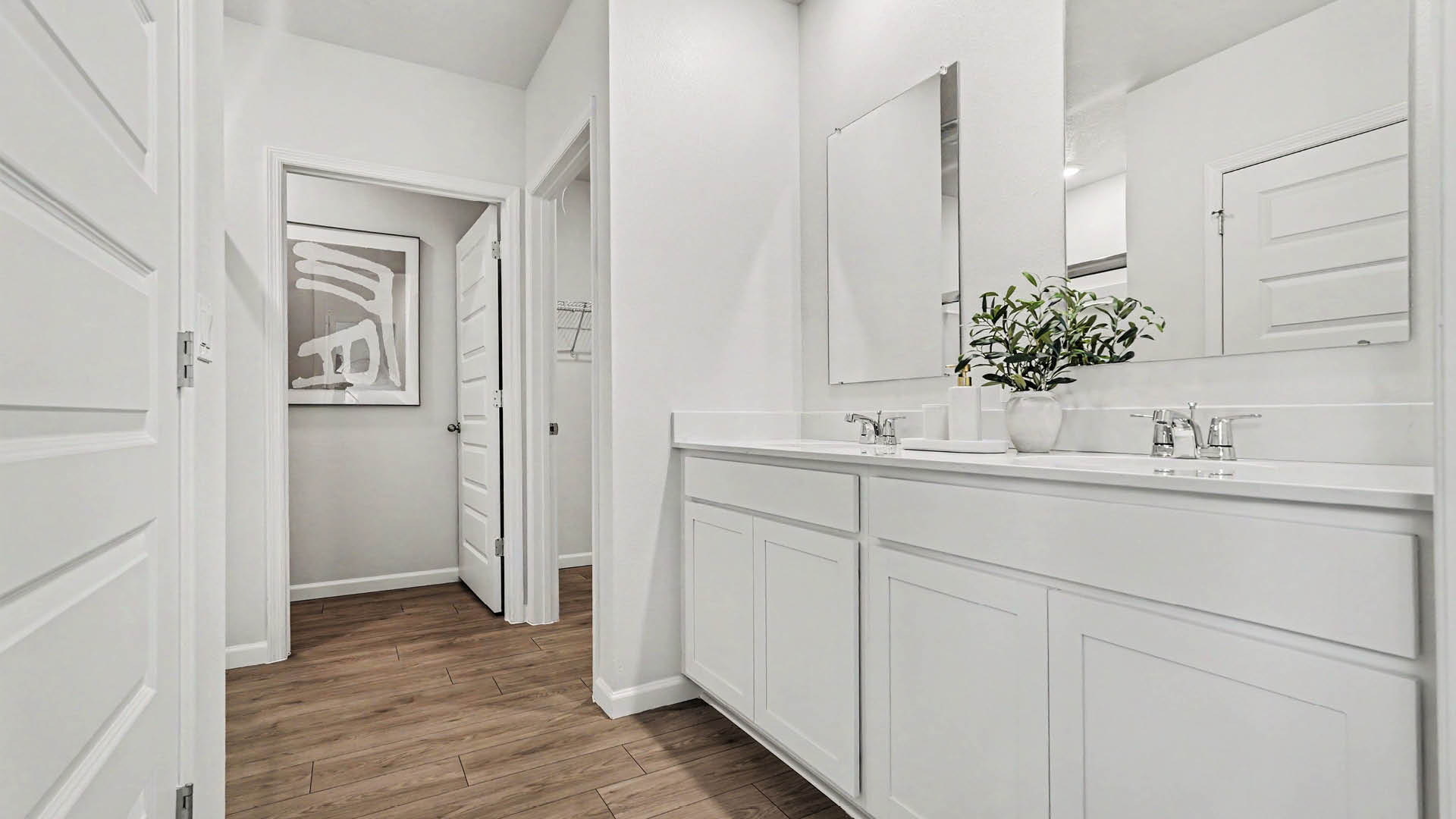 A spacious, modern bathroom featuring a double sink vanity and bright lighting.