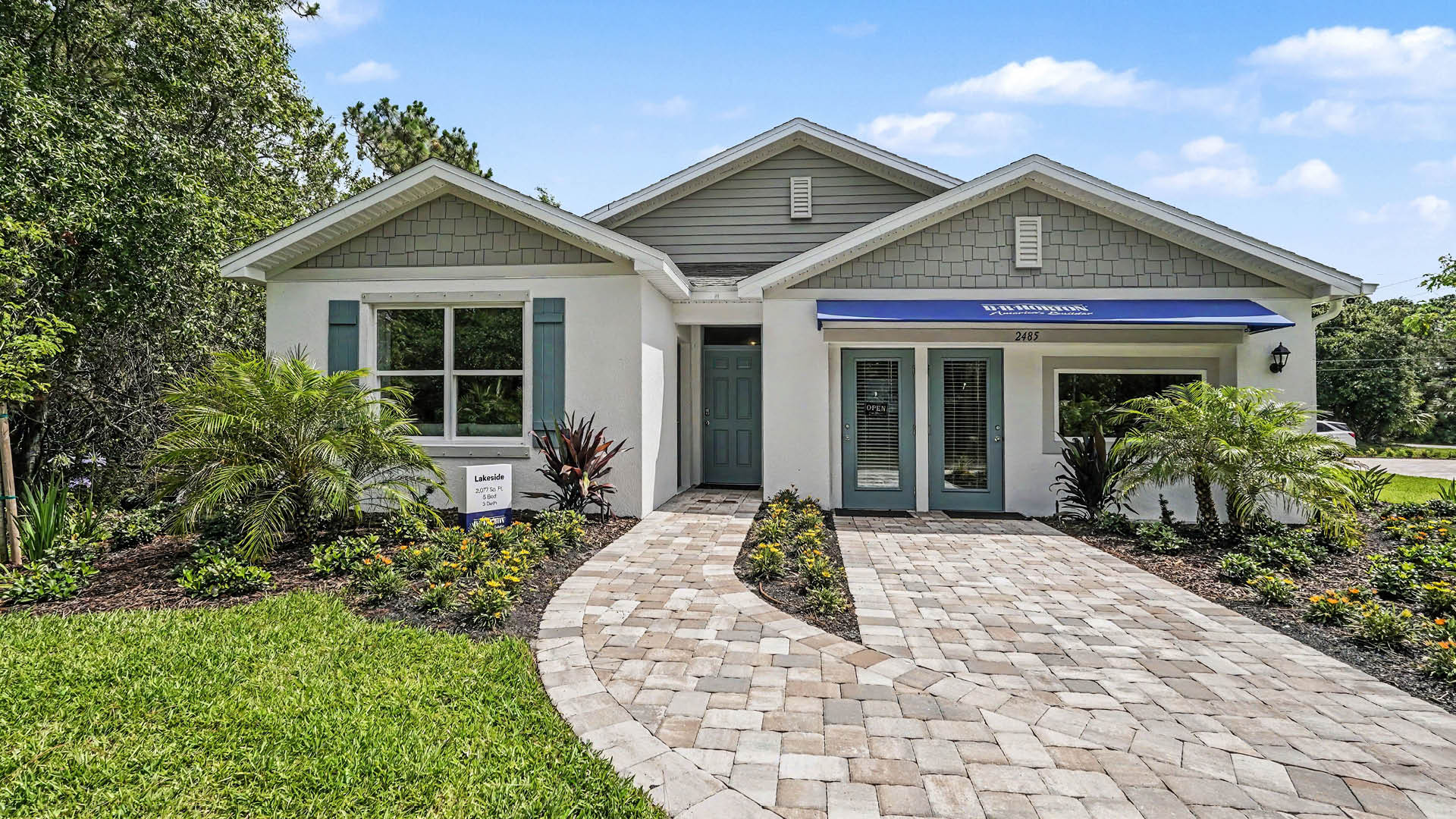 An exterior photo showing a modern home with a shingled roof and manicured landscaping.