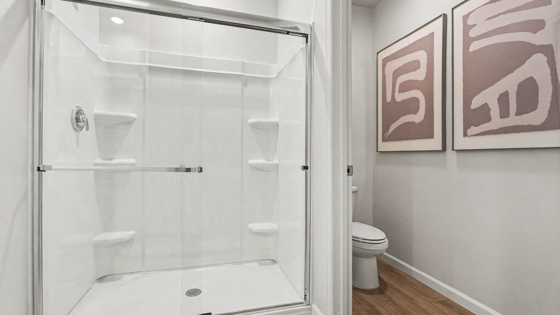 A spacious, modern bathroom featuring a glass, walk-in shower and separate toilet area.