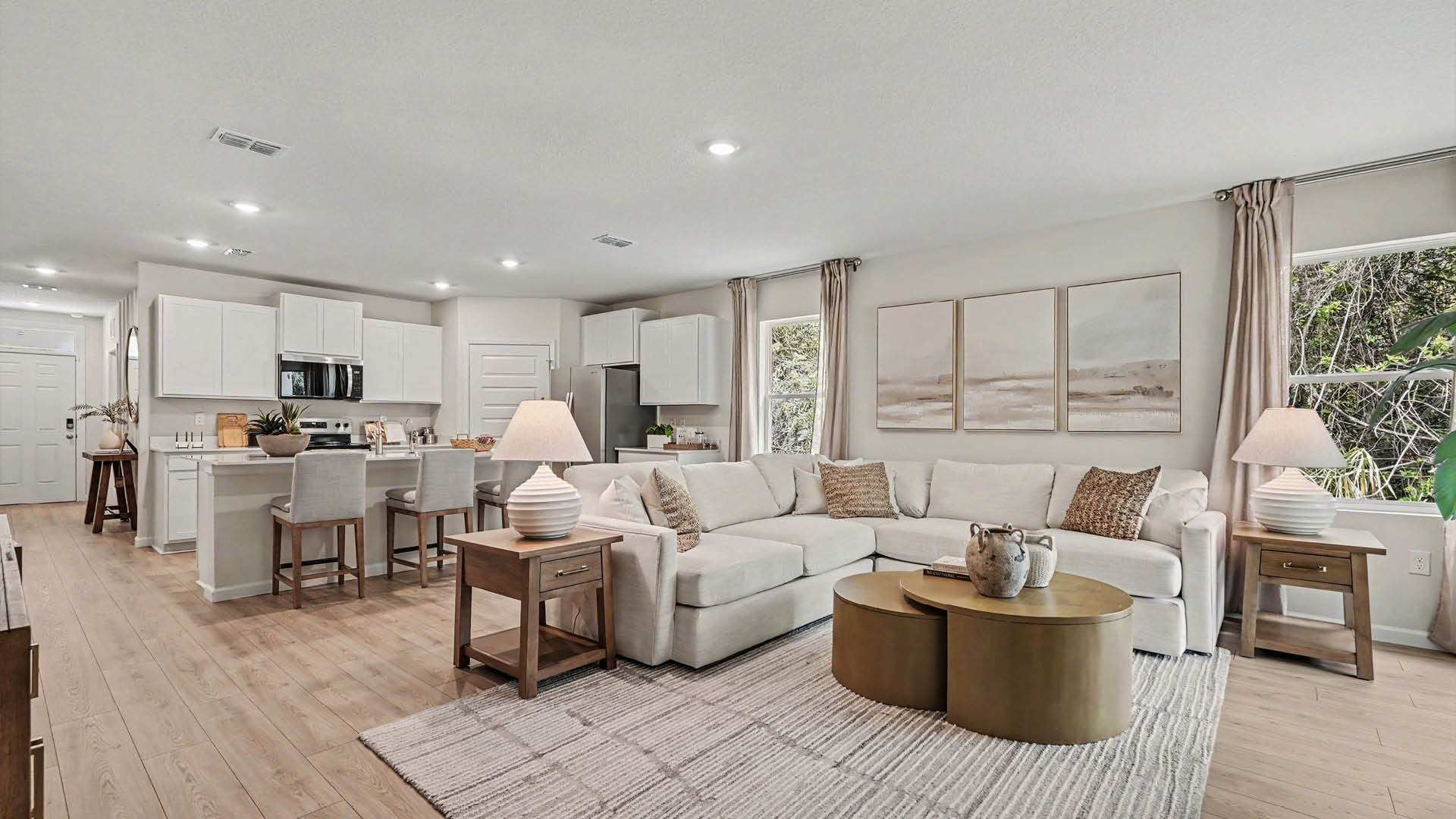 A spacious room, with a dining and kitchen area and Mohawk® Revwood Select Plank Flooring throughout.  An entryway hallway leading to the front door is visible.