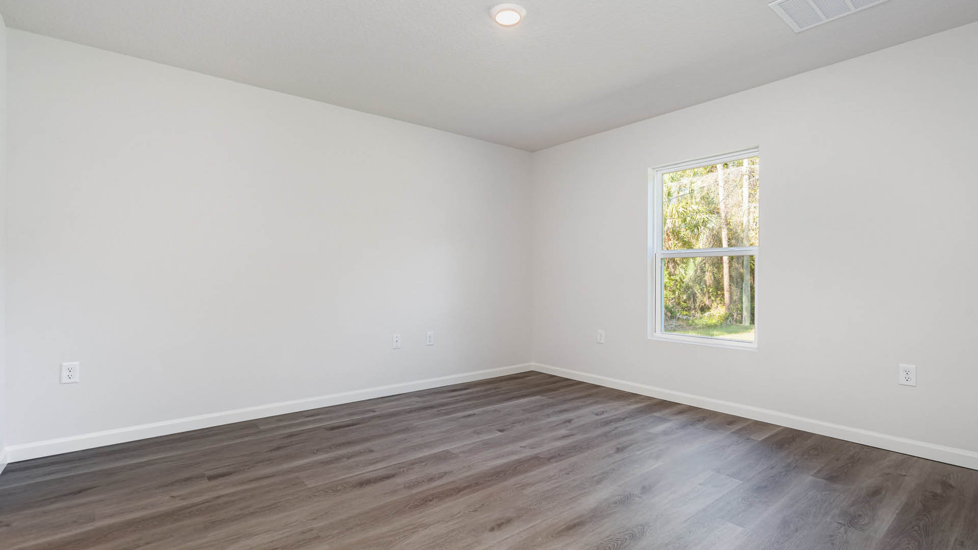 A large bedroom with a window.