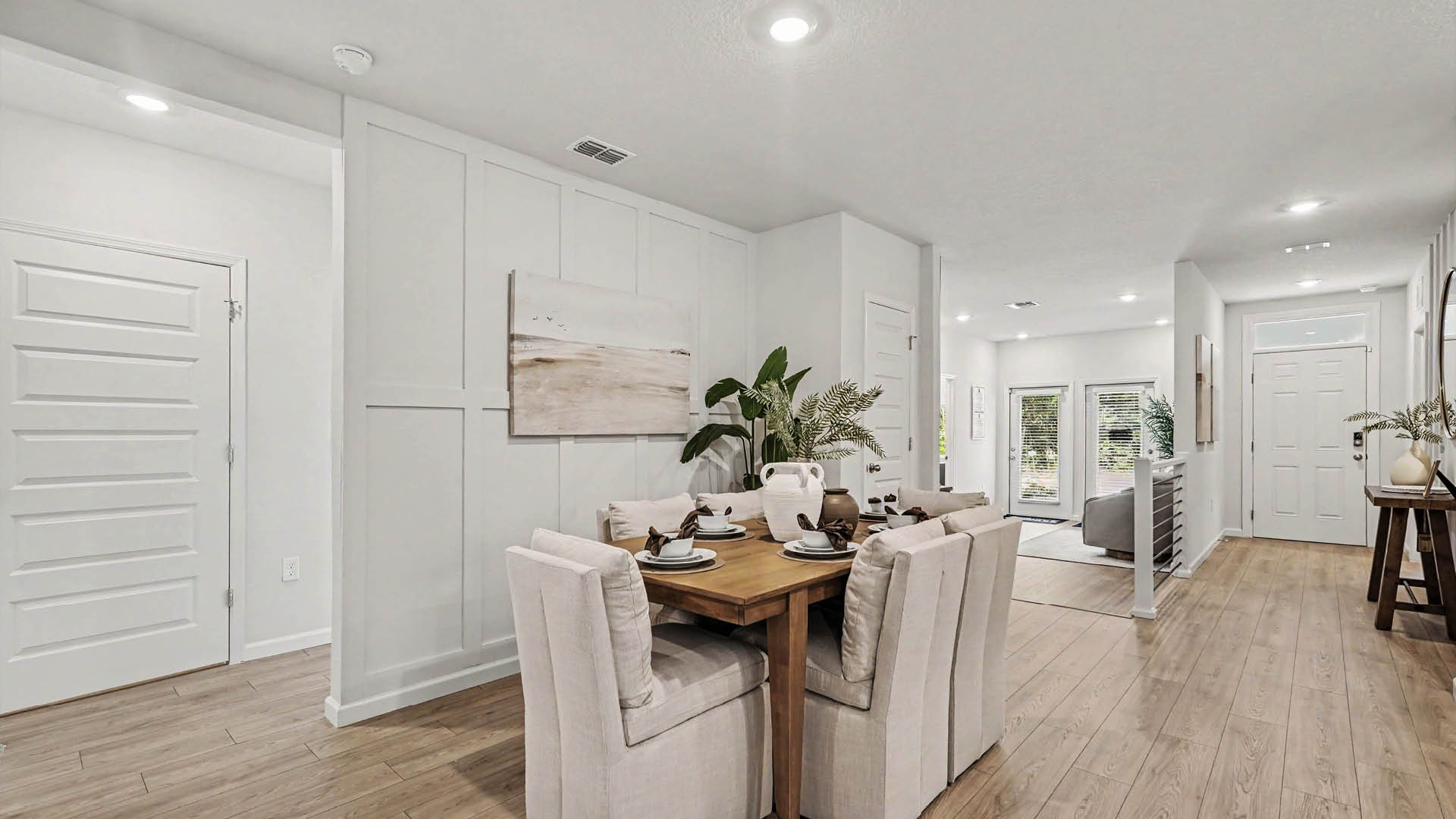 A spacious dining area featuring Mohawk® Revwood Select Plank Flooring throughout.  Multiple doors leading to other rooms are visible.