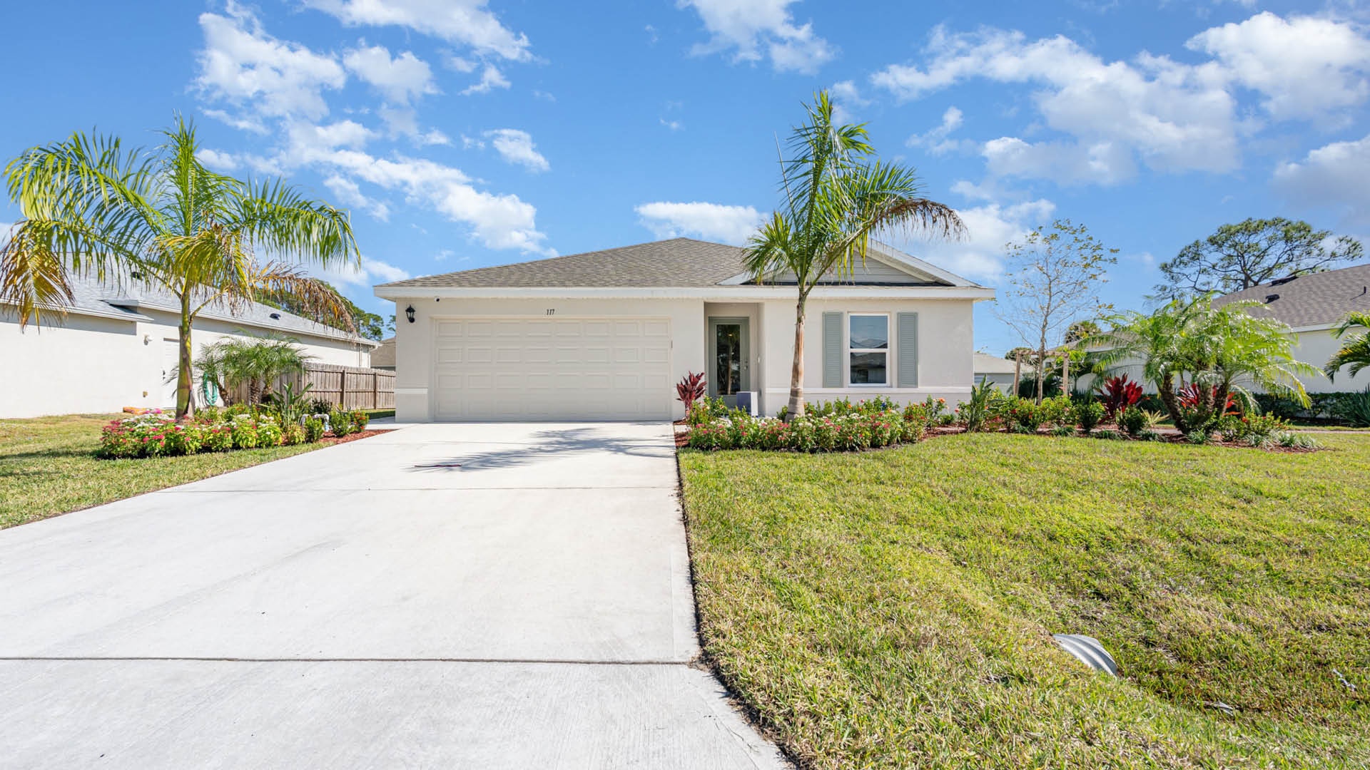 Single-story home with two-car garage and blue shutters.