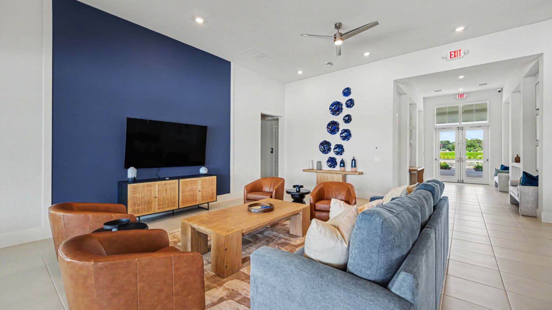 A small gathering area with couches, a TV, and several lounge chairs.