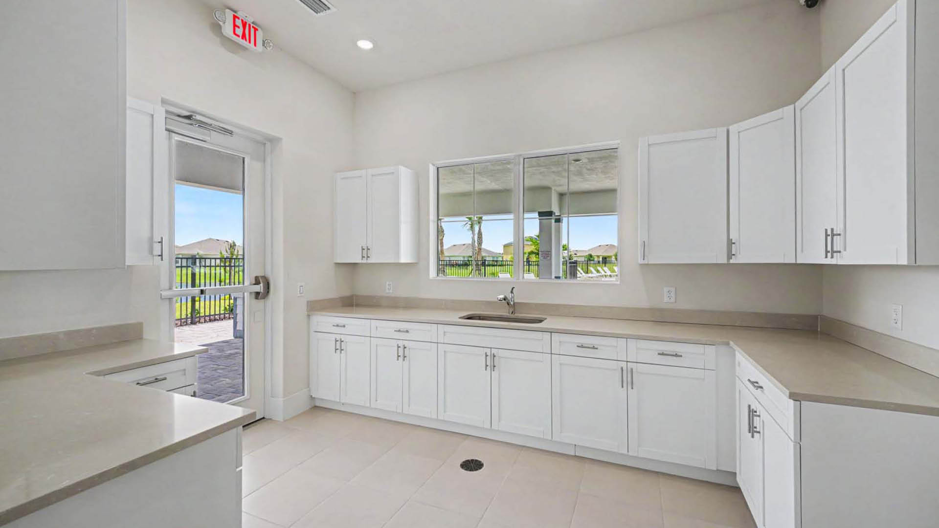 A community kitchenette with a lot of countertop and cabinet space as well as a sink.
