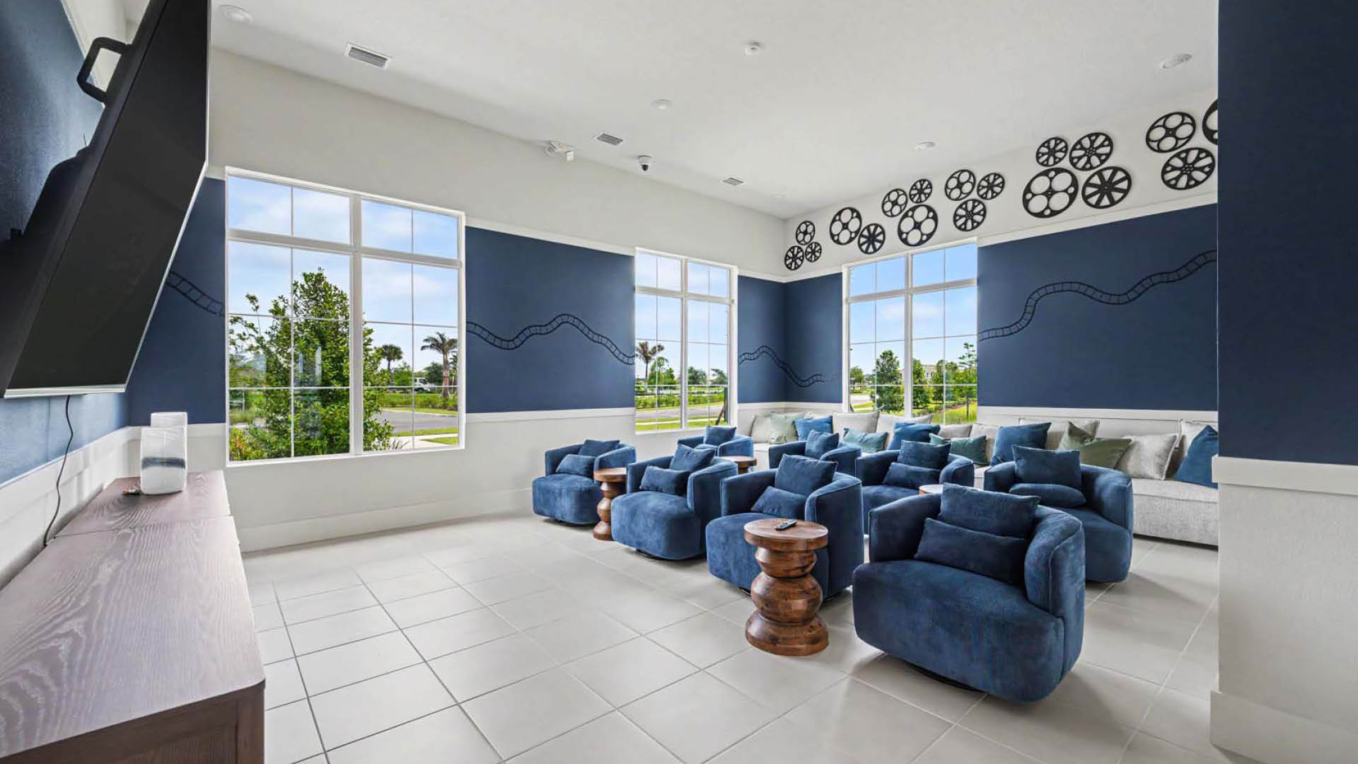 A movie viewing room with several rows of plush seating options.