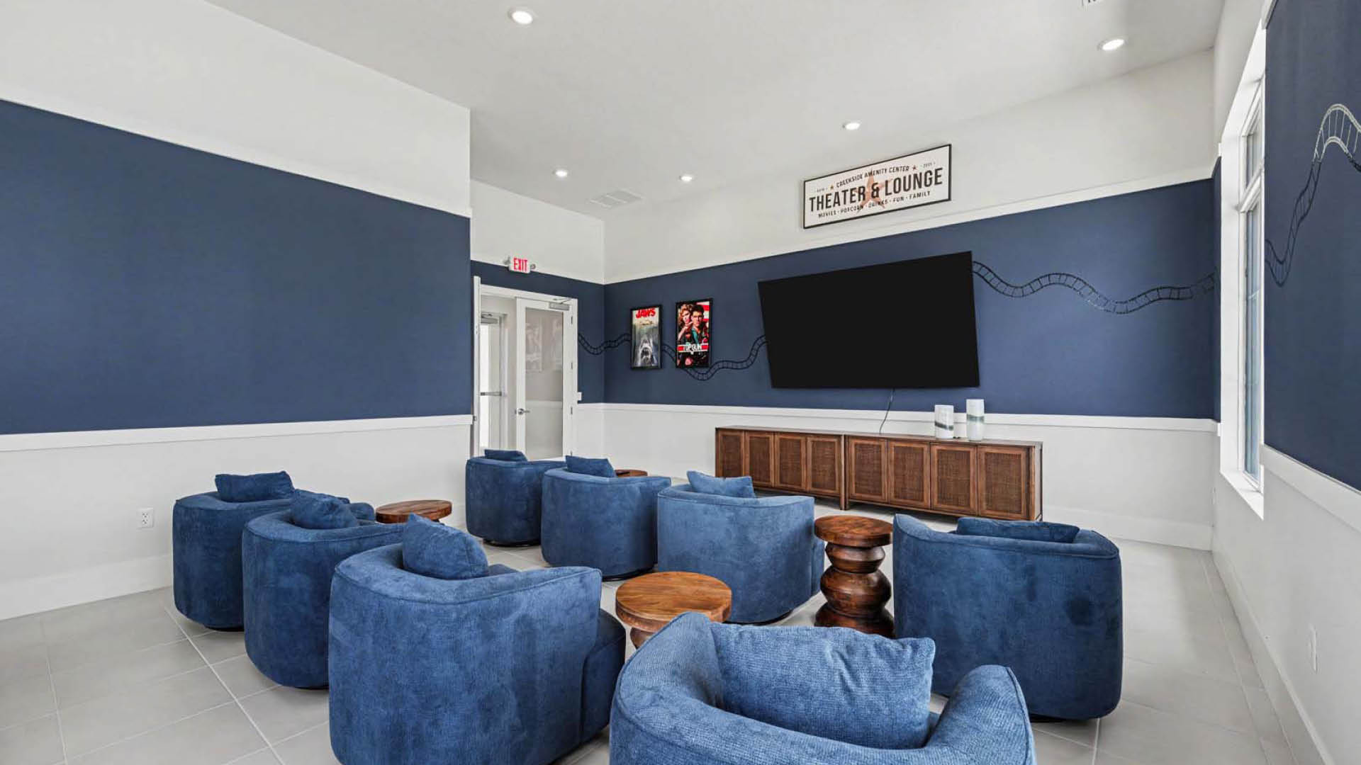 A movie viewing room with several rows of plush seating options.