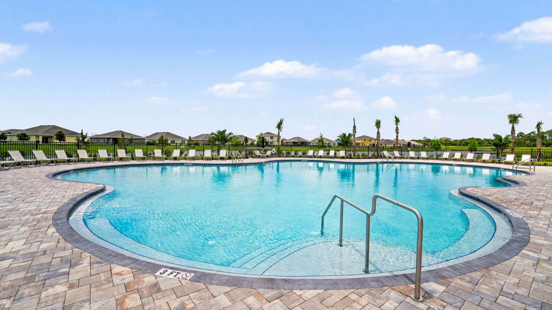 A large pool with lounge chairs surrounding the perimeter.