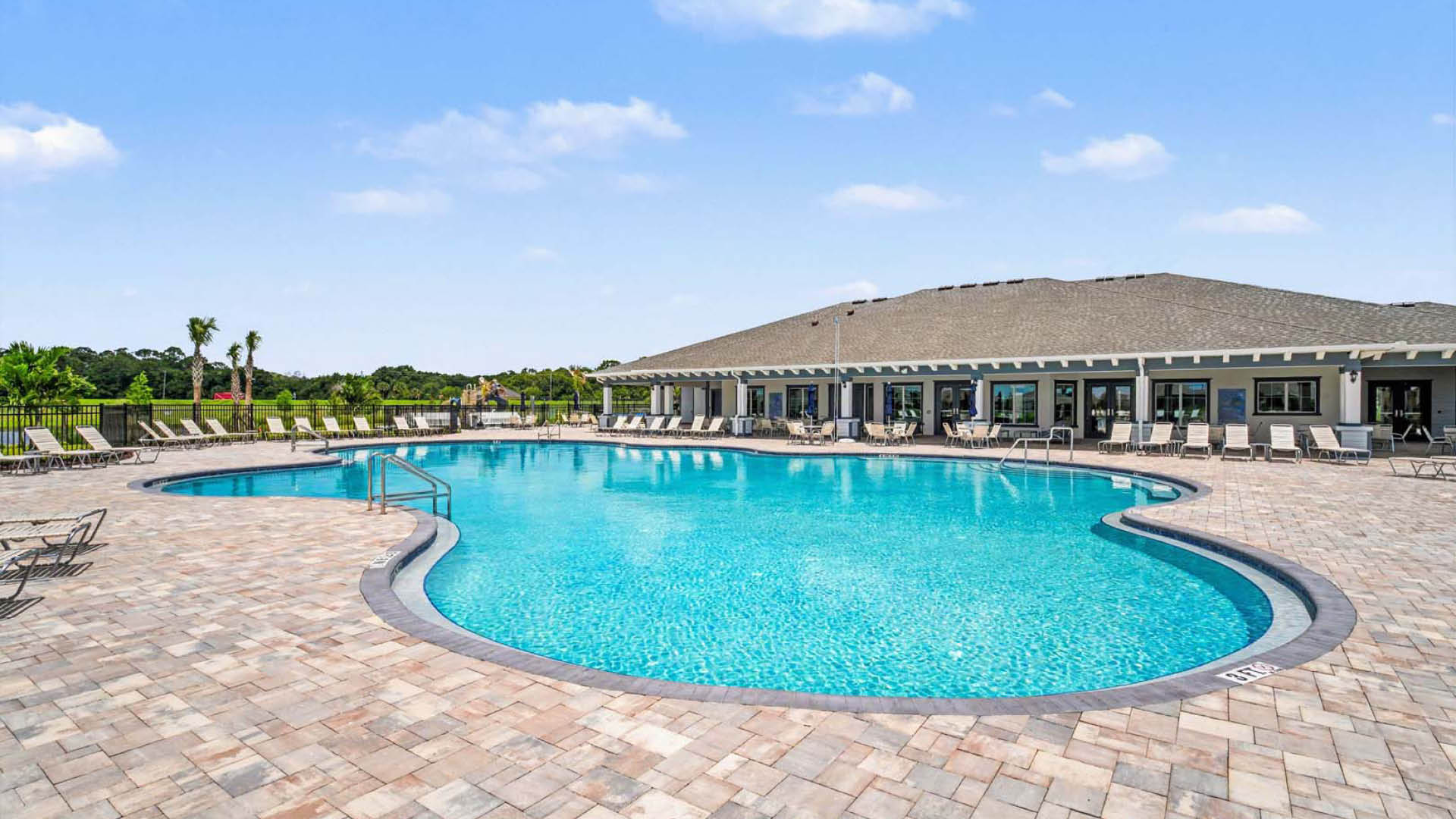 A large pool with lounge chairs surrounding the perimeter.