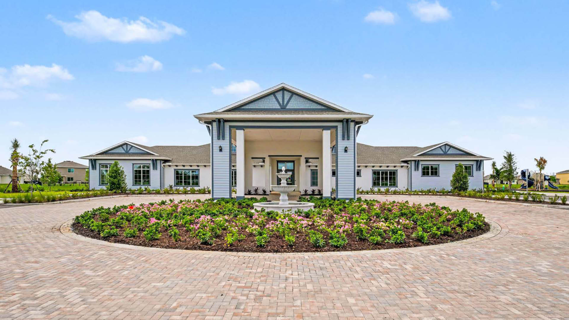 A large community building with a circular paver entrace.