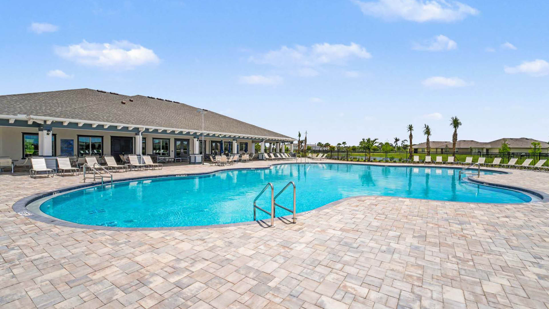 A large pool with lounge chairs surrounding the perimeter.