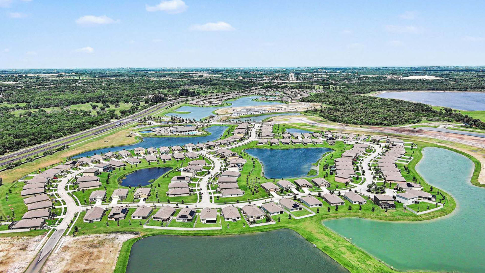 An aerial view of a well-built community with several water features throughout.