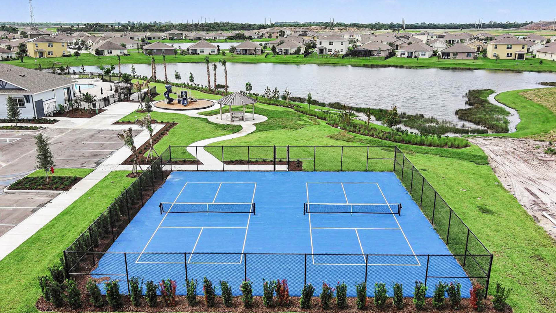 An aerial view of a pickleball court surrounded by lush greenery.
