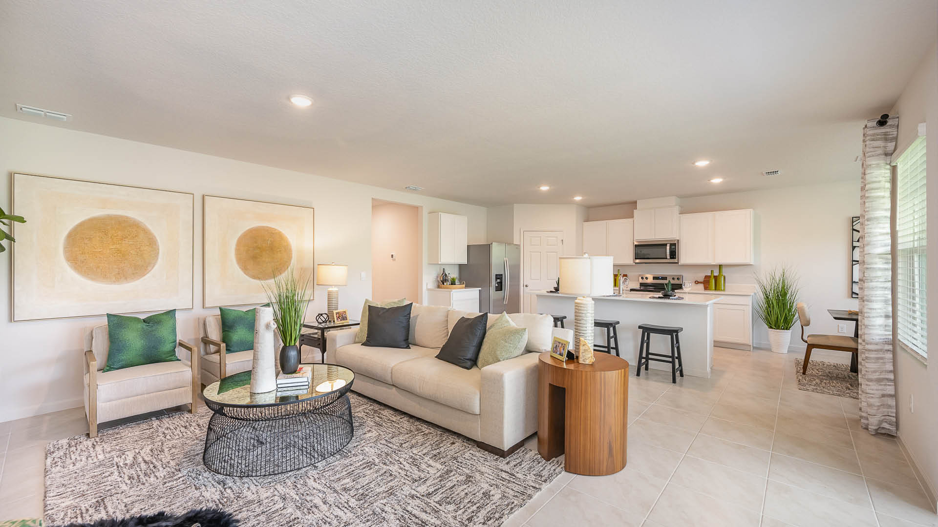 Bright, open living area with tile flooring, modern kitchen, and sliding doors leading to a patio; neutral walls enhance spaciousness.