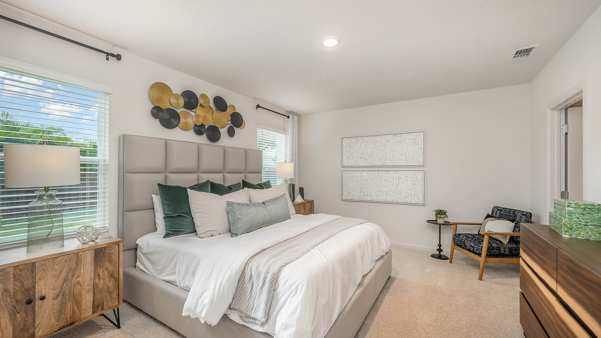 Cozy modern bedroom with a plush bed, decorative pillows, stylish wall art, and natural light from a window, creating a serene atmosphere.
