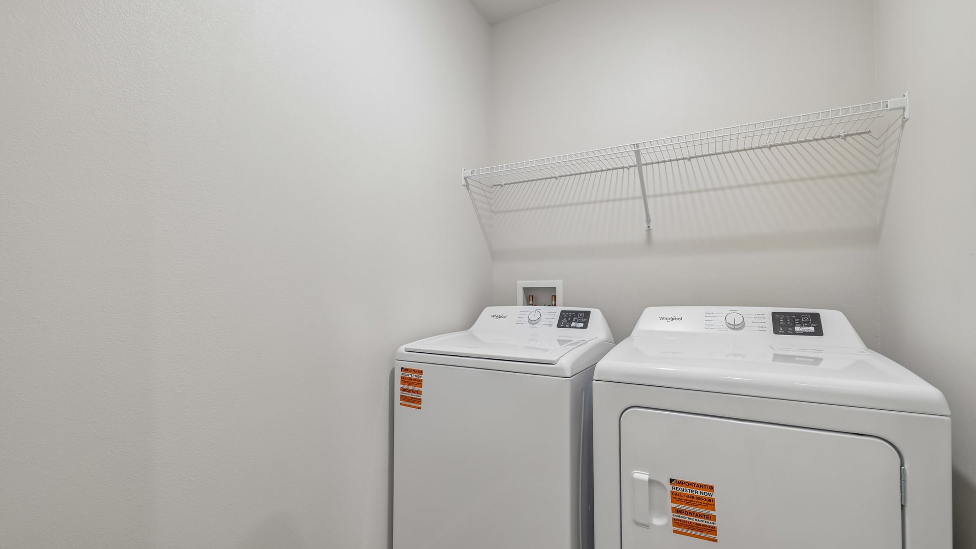 A laundry room with white wire shelves.