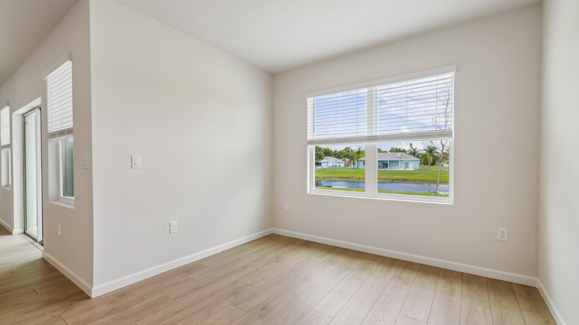 A cozy dining area with a large window with blinds. A sliding glass door is also visible.