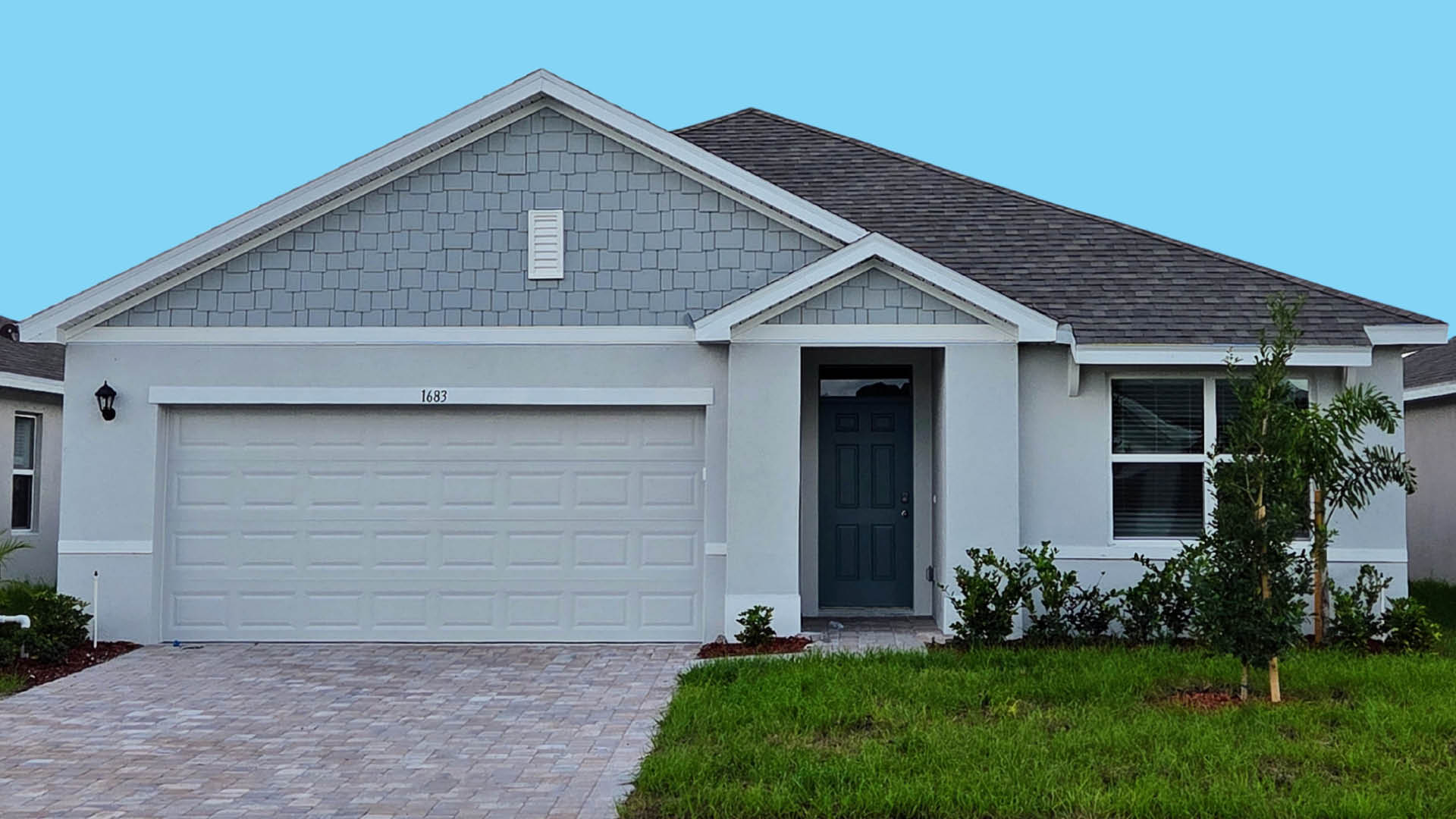 An exterior photo showing a modern single-family home with a shingled roof and manicured landscaping.