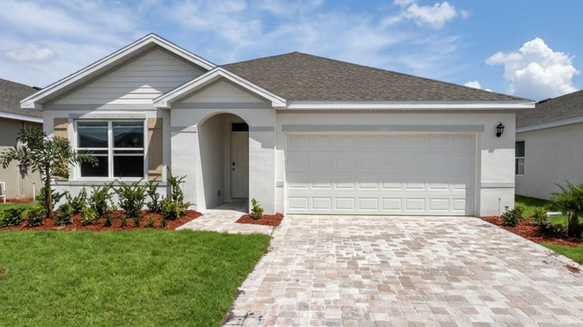 An exterior photo showing a modern single-family home with a shingled roof and manicured landscaping.