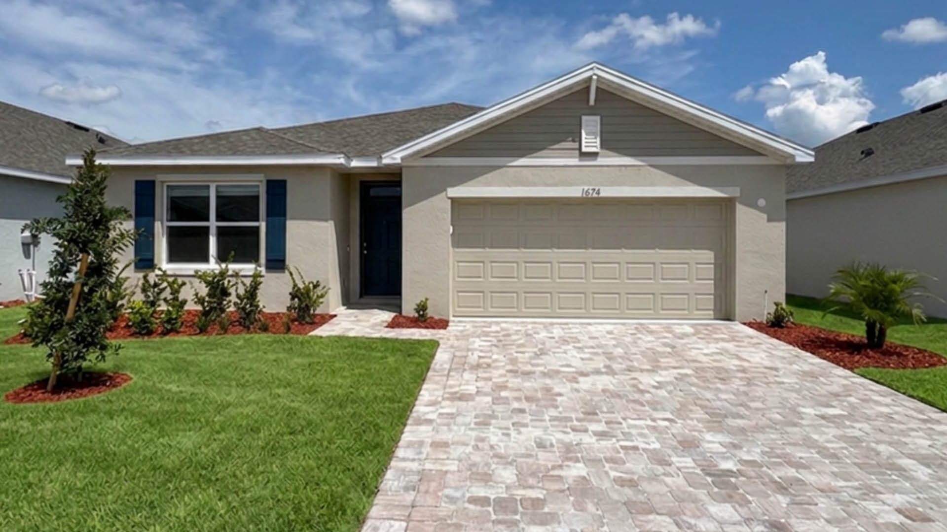 An exterior photo showing a modern single-family home with a shingled roof and manicured landscaping.