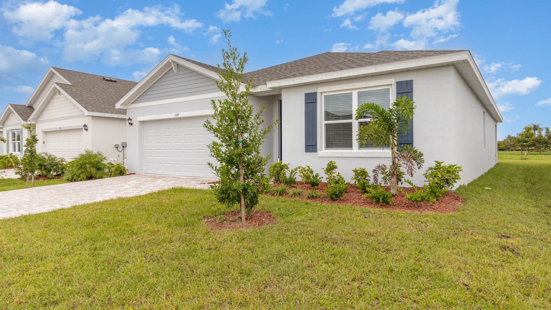 An exterior photo showing a modern single-family home with a shingled roof and manicured landscaping.