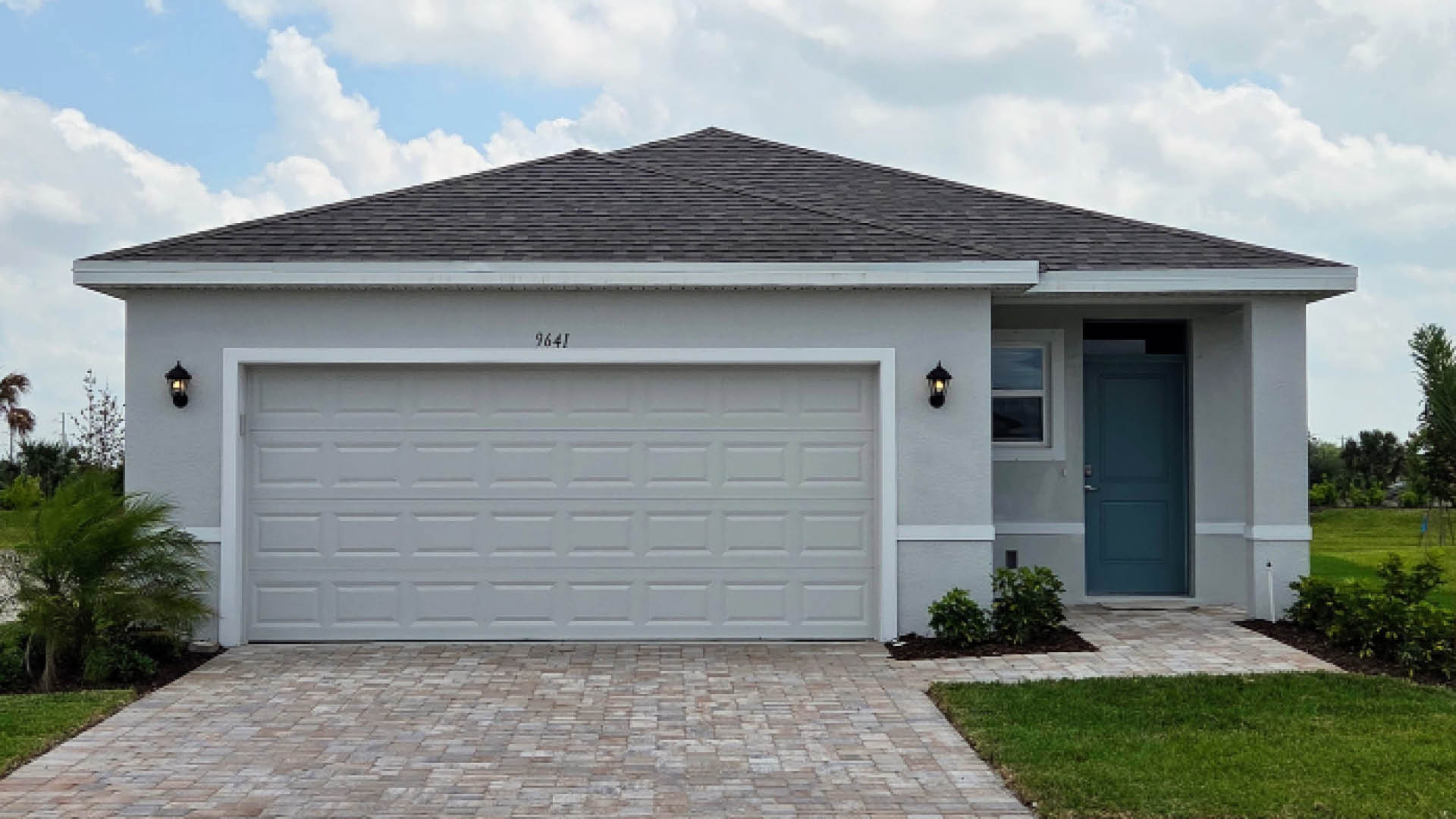 An exterior photo showing a modern single-family home with a shingled roof and manicured landscaping.