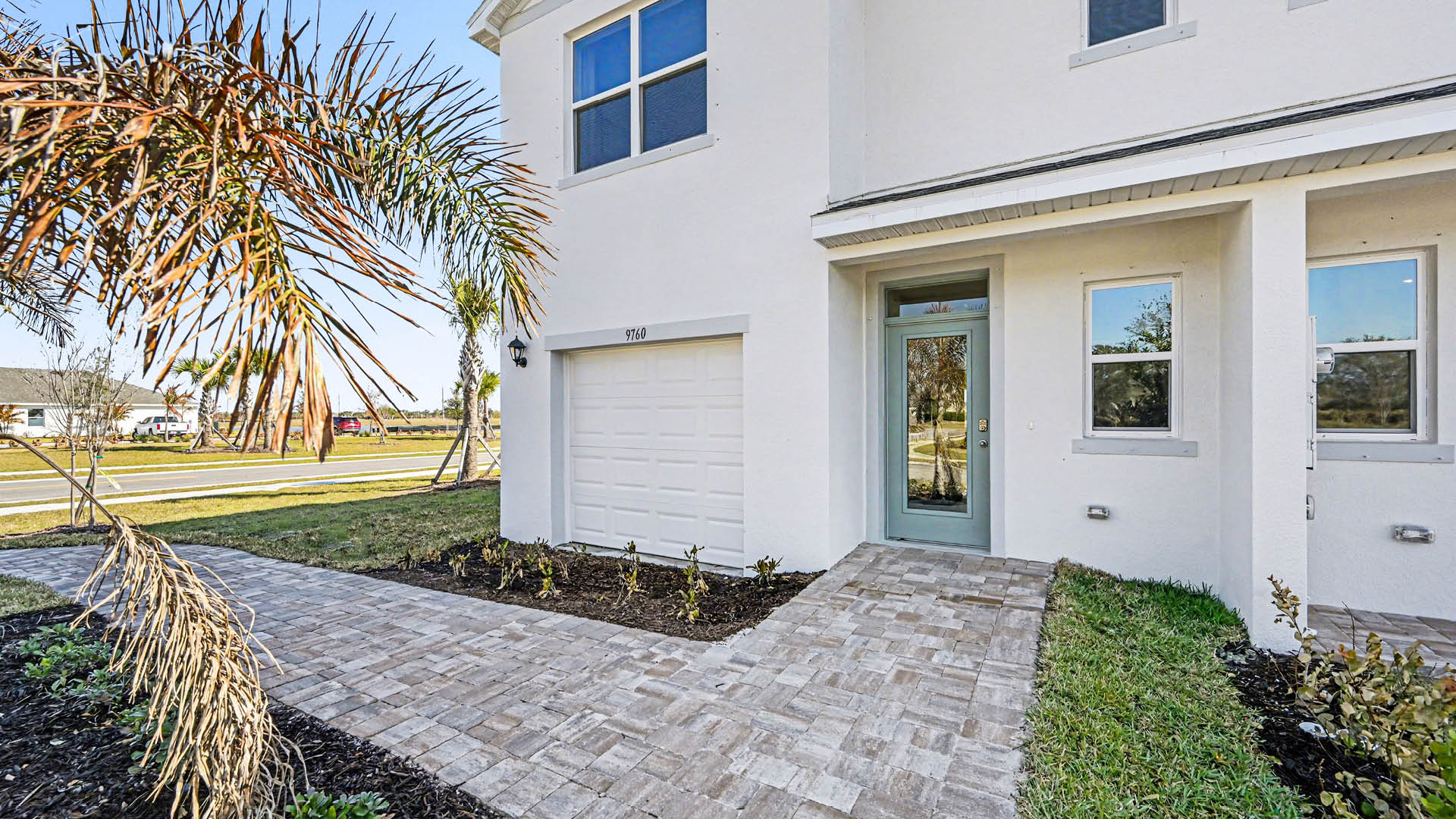 A townhome with a single-car garage, covered doorway, and Brick Paver walkway.