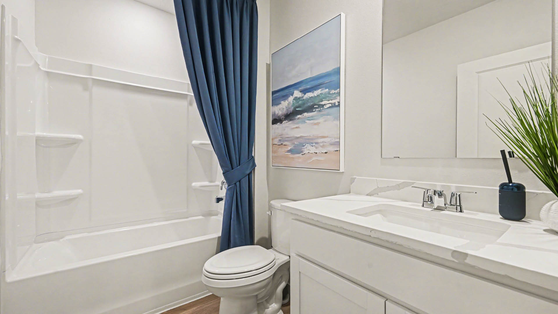 A clean, modern bathroom featuring a white sink, a bathtub with a shower, and a large mirror against neutral-colored walls.