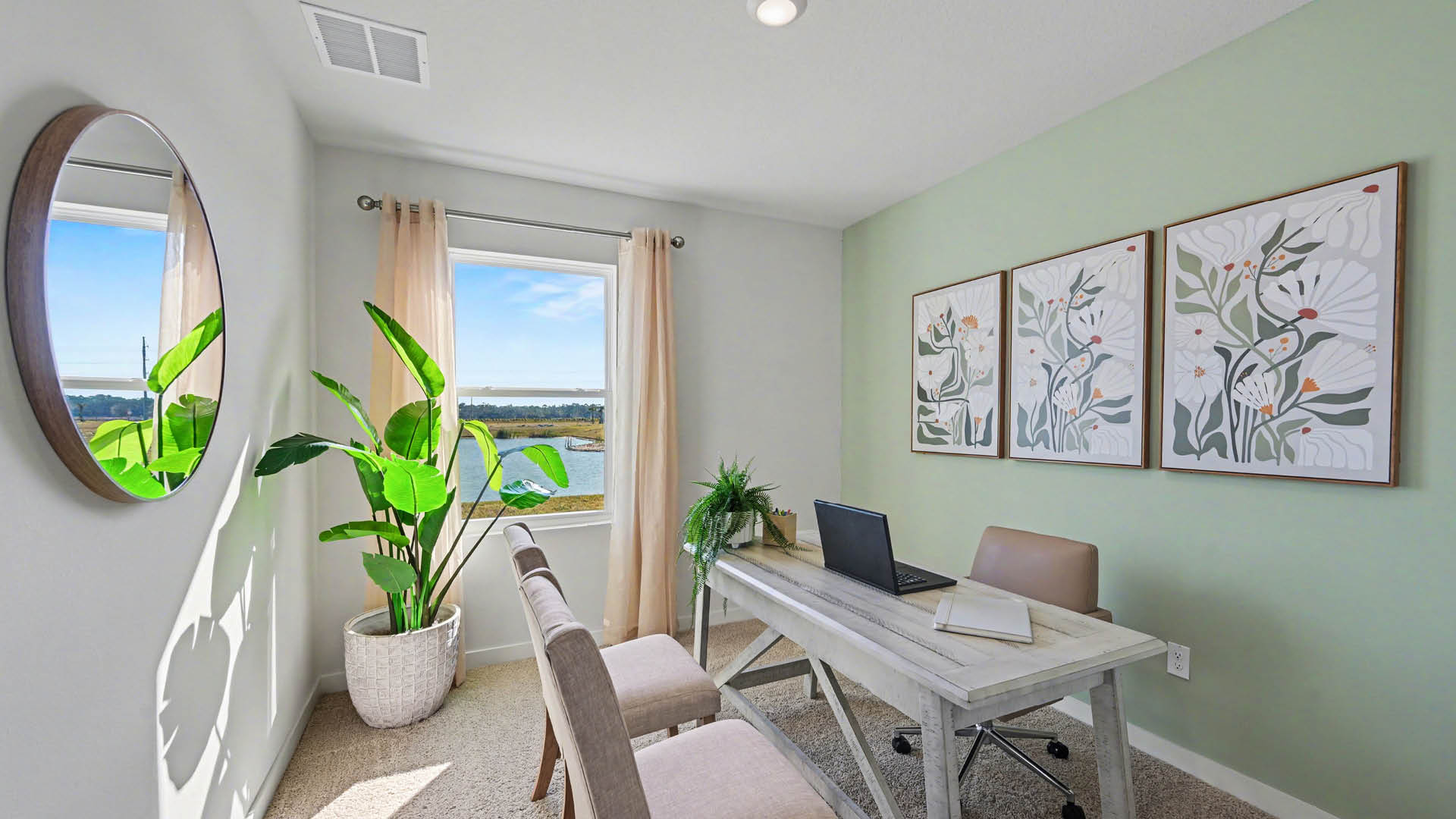 A home-office with beige carpet, white walls, and a window, allowing natural light to illuminate the space.