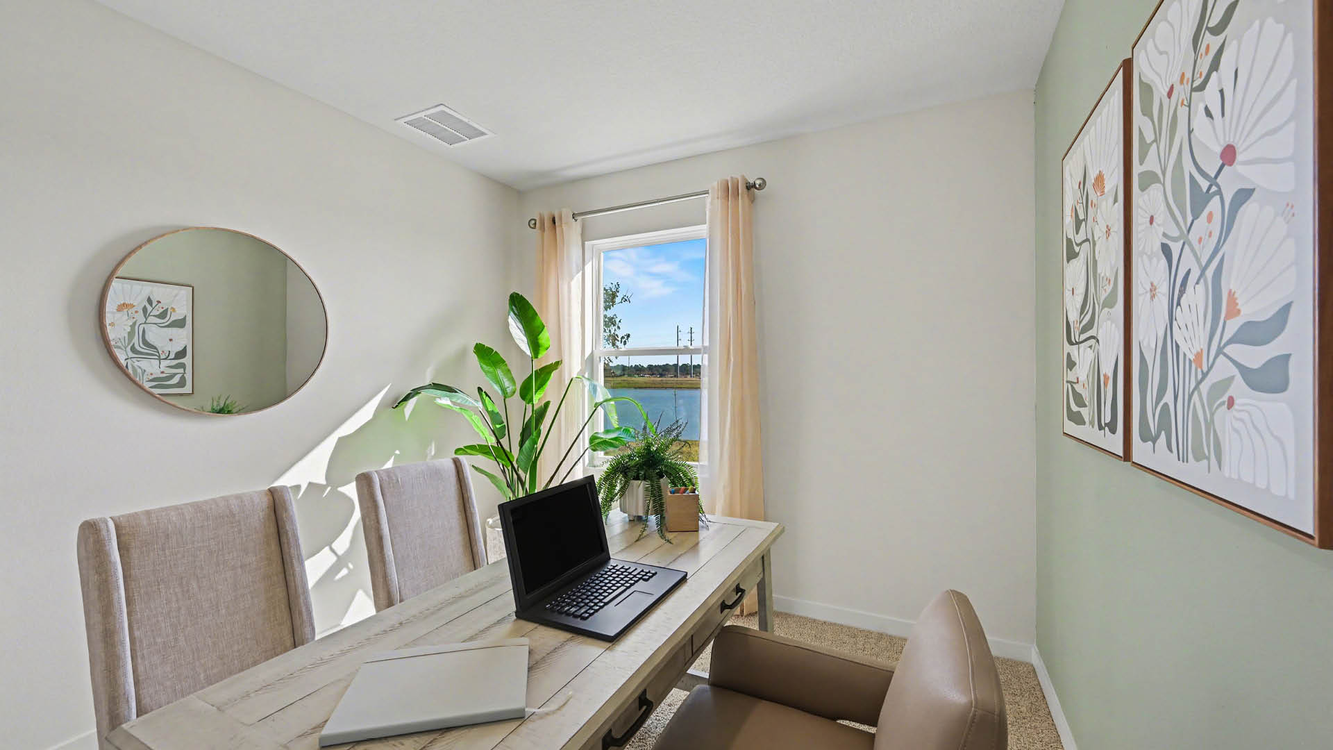 A home-office with beige carpet, white walls, and a window, allowing natural light to illuminate the space.