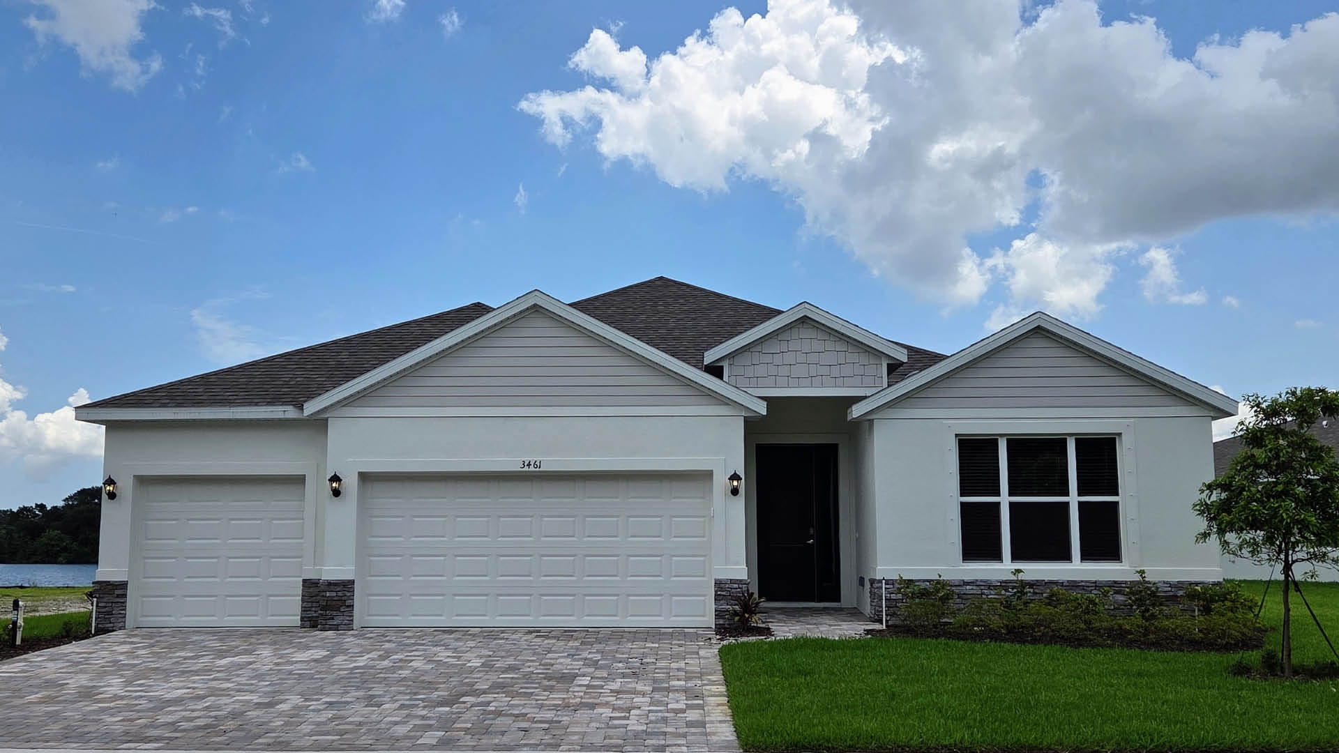 An exterior photo showing a modern single-family home with a shingled roof and manicured landscaping.
