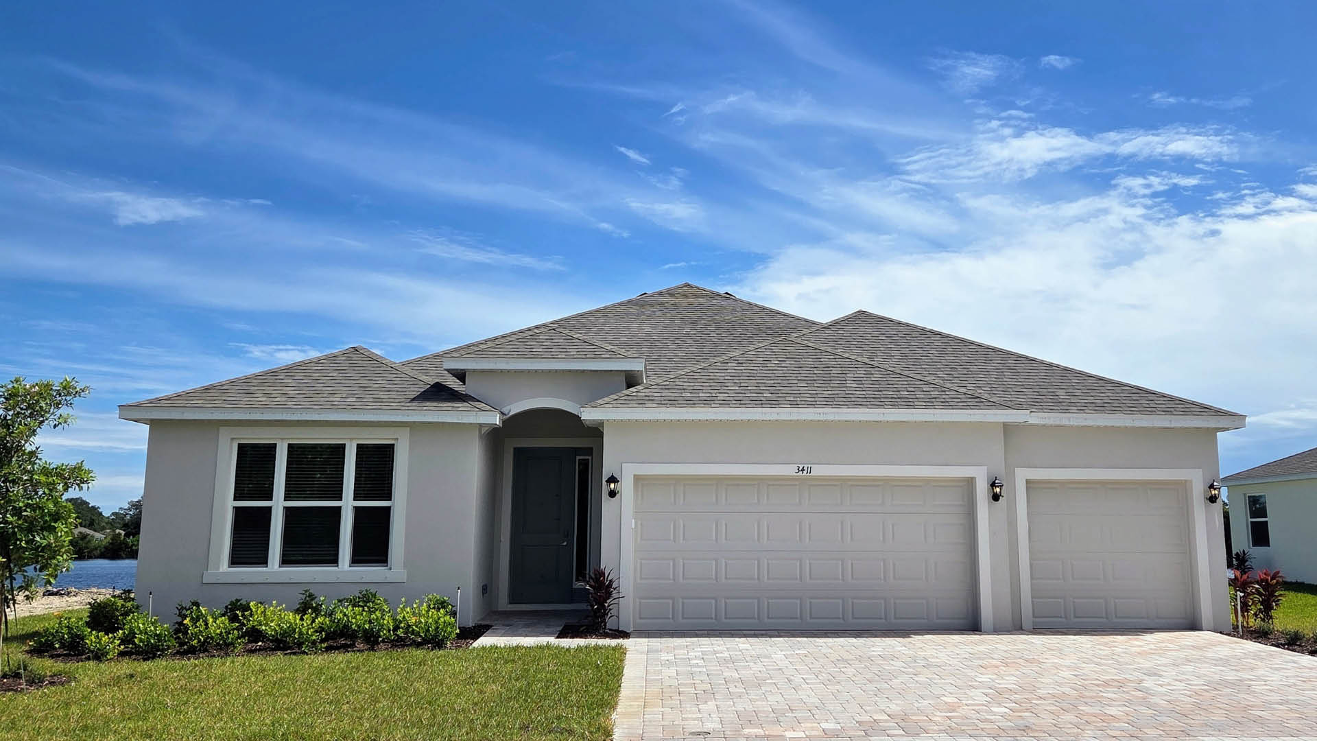 An exterior photo showing a modern single-family home with a shingled roof and manicured landscaping.