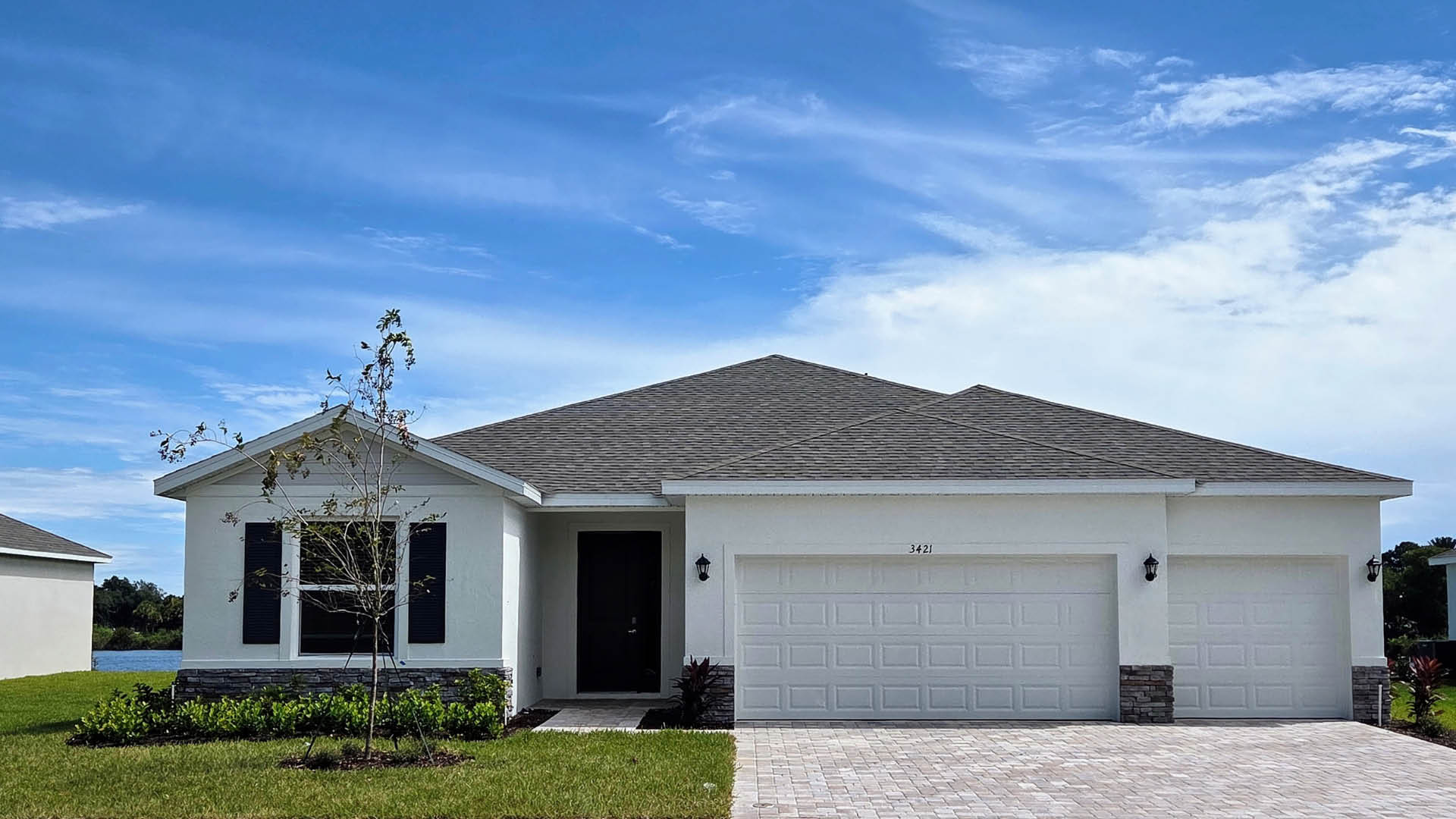 An exterior photo showing a modern single-family home with a shingled roof and manicured landscaping.