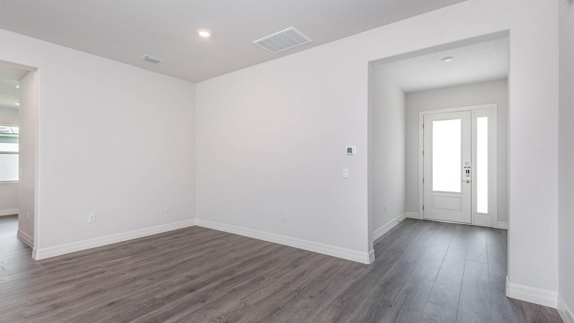 Empty room featuring vinyl plank floors and plain white walls, creating a bright and spacious atmosphere.