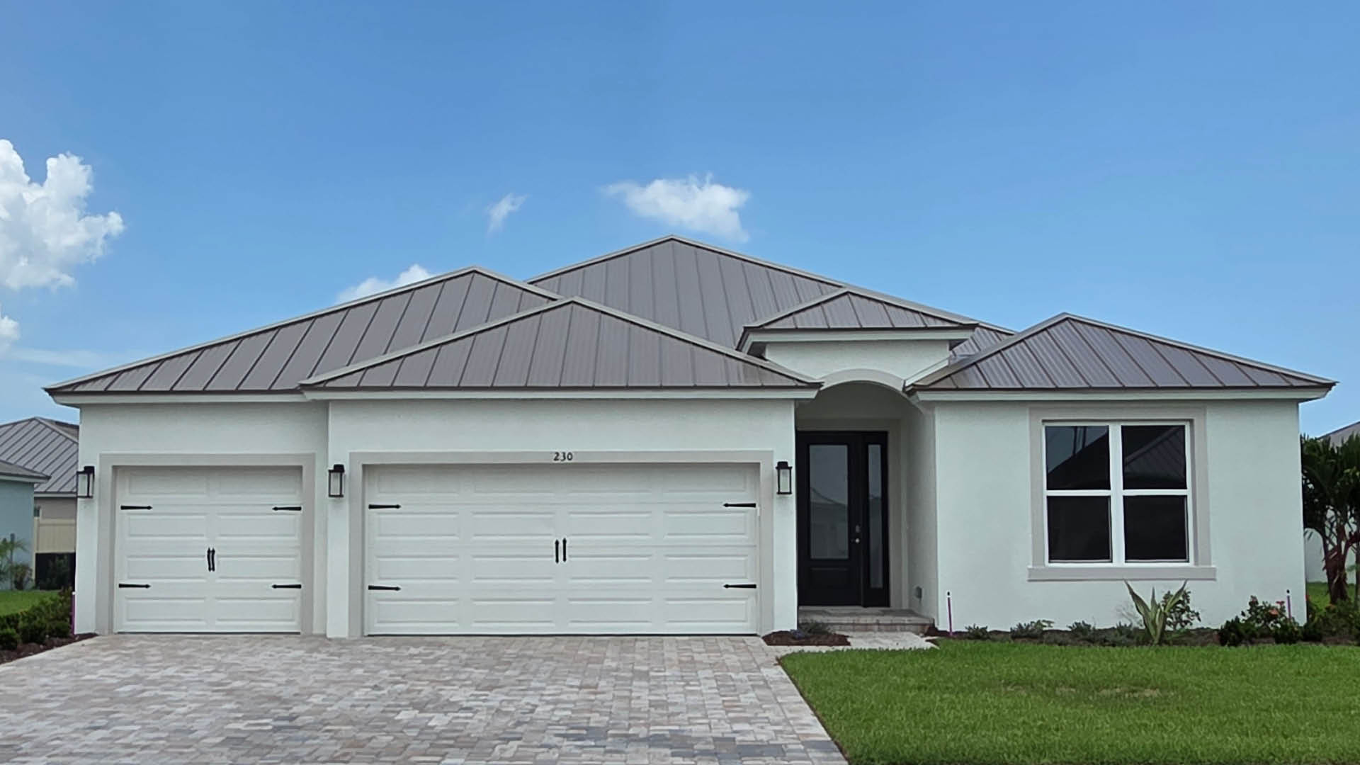 An exterior photo showing a modern single-family home with a shingled roof and manicured landscaping.