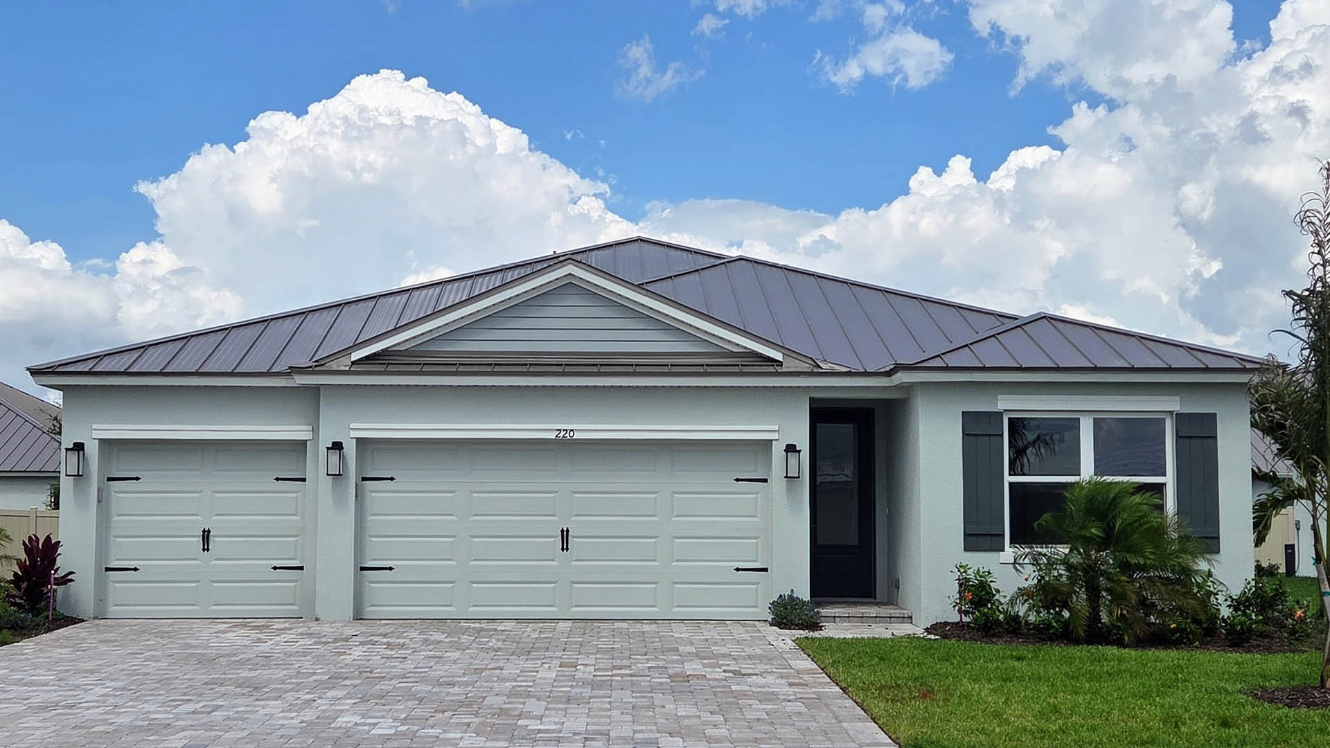 An exterior photo showing a modern single-family home with a shingled roof and manicured landscaping.