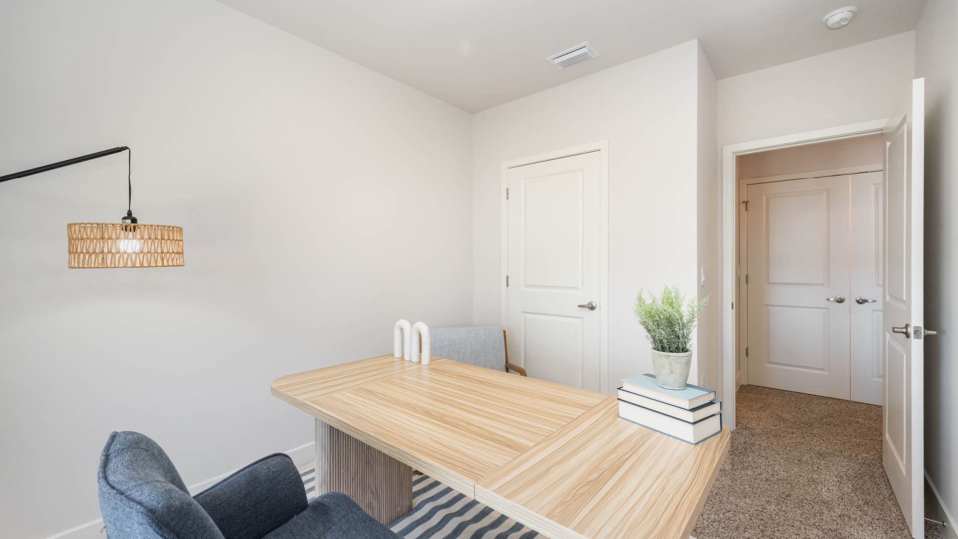 Cozy home office with blue desk chair, light wood tone desk.