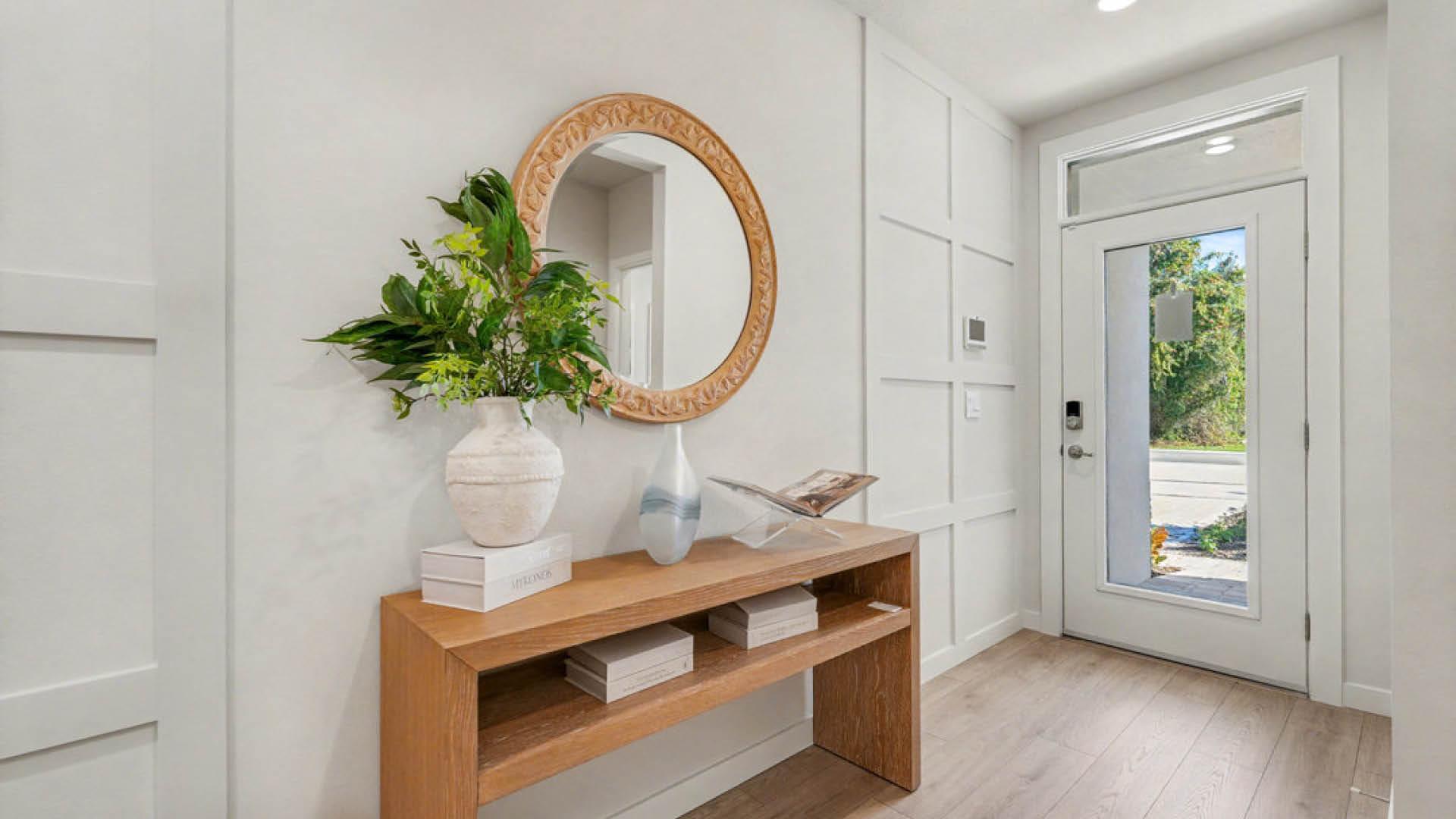 A hallway featuring a wooden table and a decorative mirror on the wall.