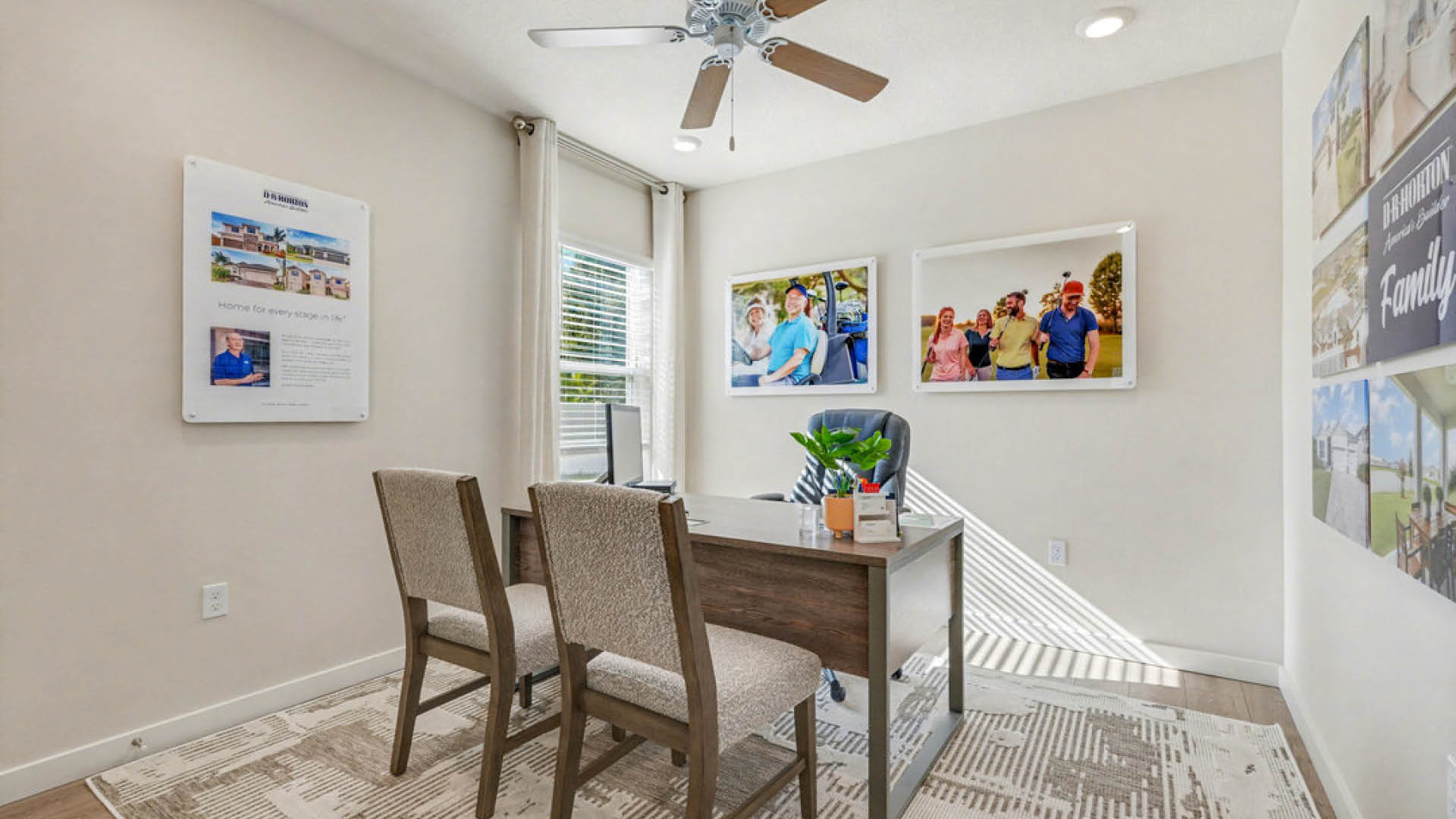 A home office featuring a ceiling fan and framed pictures adorning the walls, creating a cozy work environment.