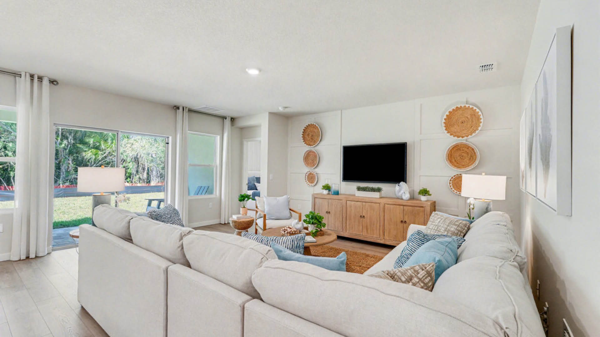 A cozy living room featuring a couch, coffee table, and a television against a neutral wall.