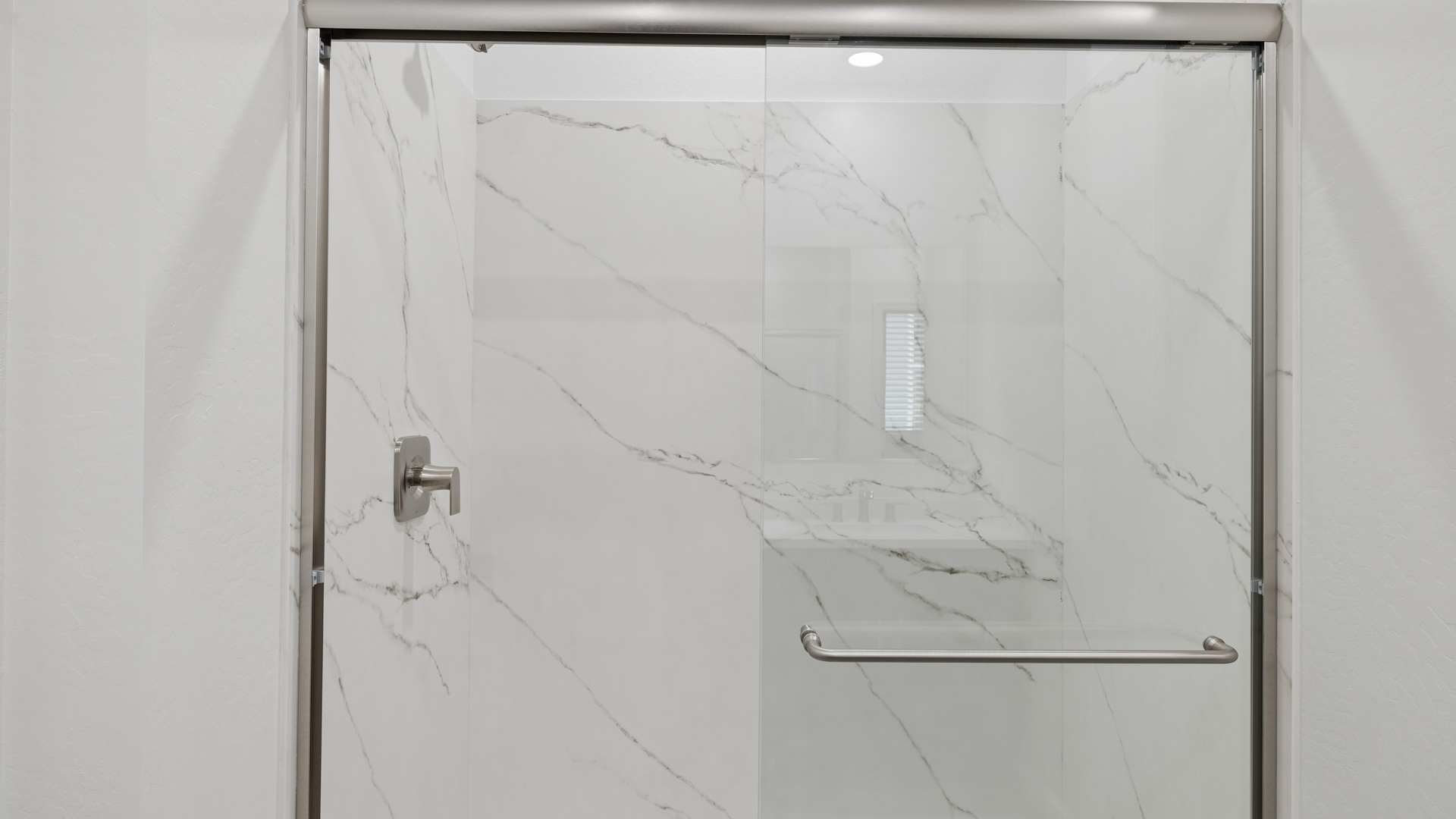 Modern primary bathroom with double vanities, countertops with a walk-in shower and a walk-in closet.