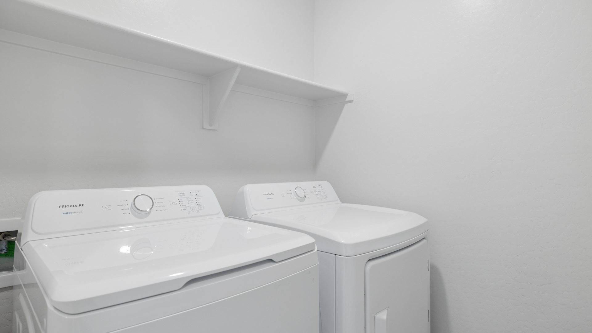 A laundry room featuring a washer and dryer, neatly arranged with ample space for laundry tasks and storage.
