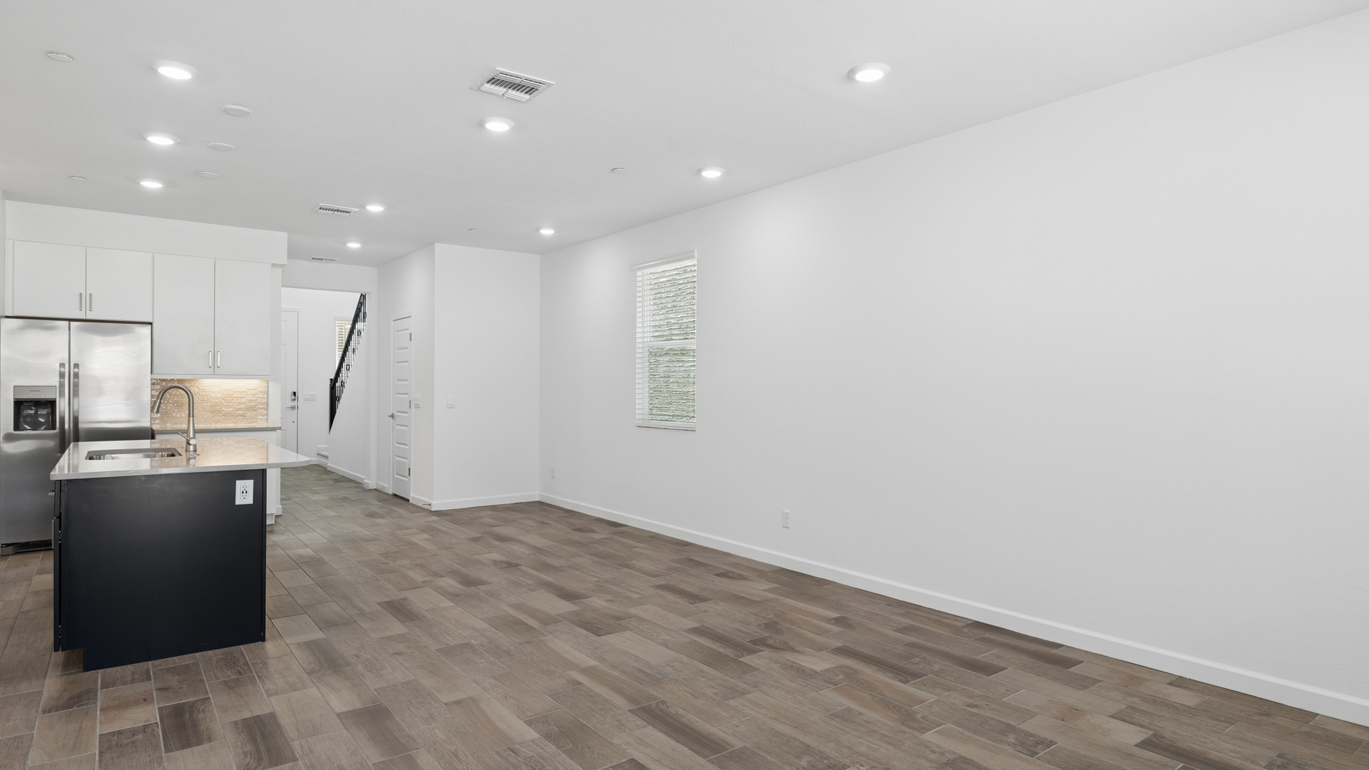 A well-organized living room that includes a kitchen and dining area, creating a warm and welcoming environment for gatherings.
