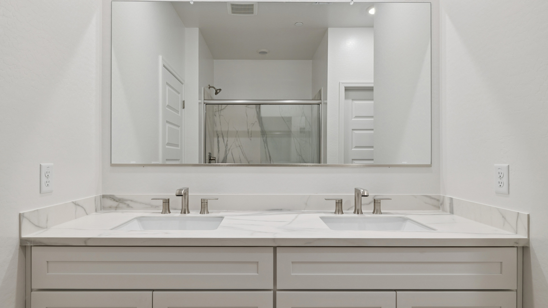 Primary bathroom with dual vanities.