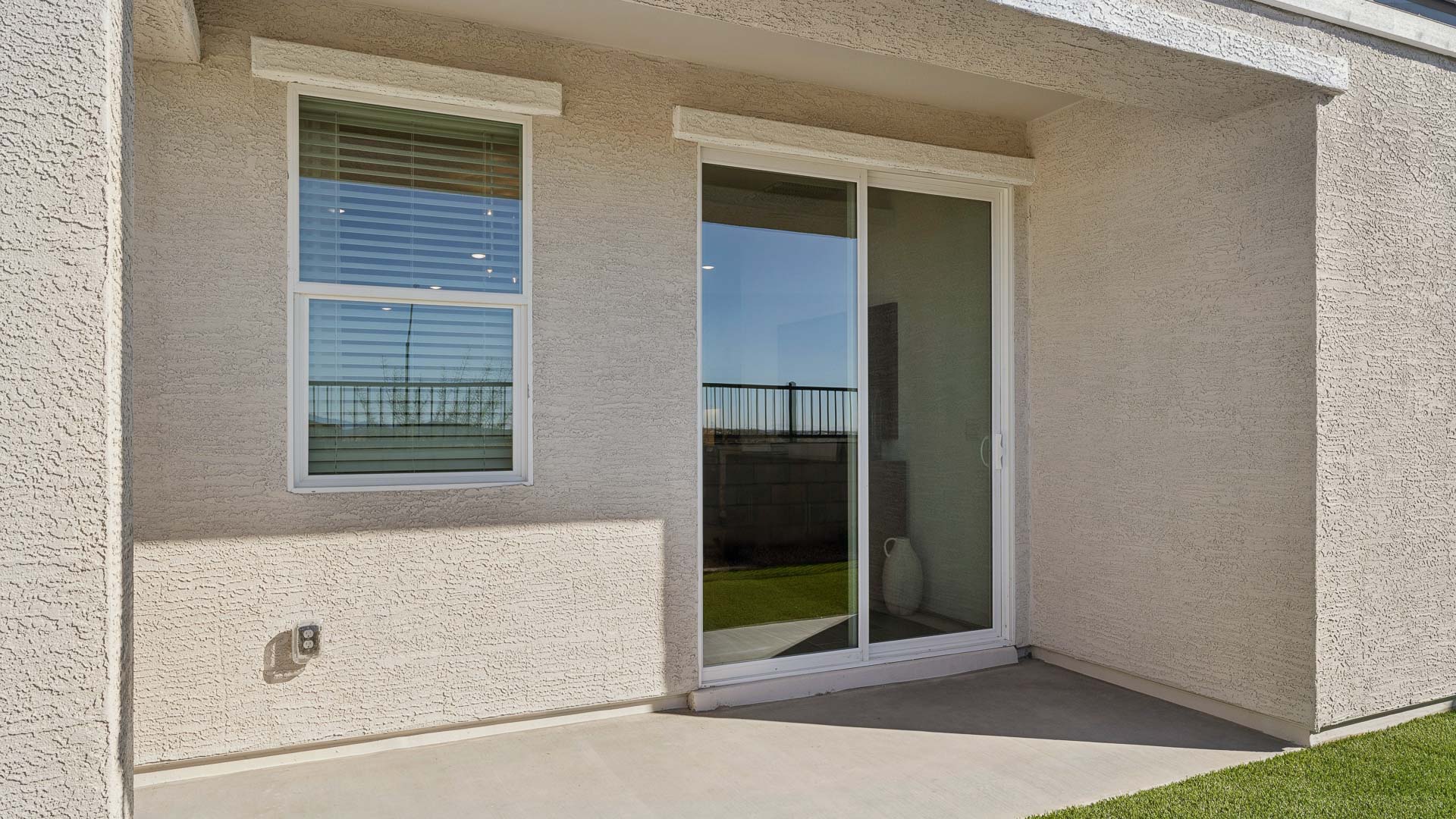 Back yard with turf and covered patio.