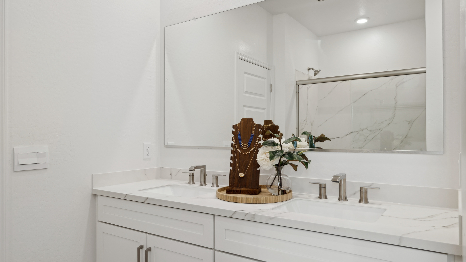 Primary bathroom with dual vanities.