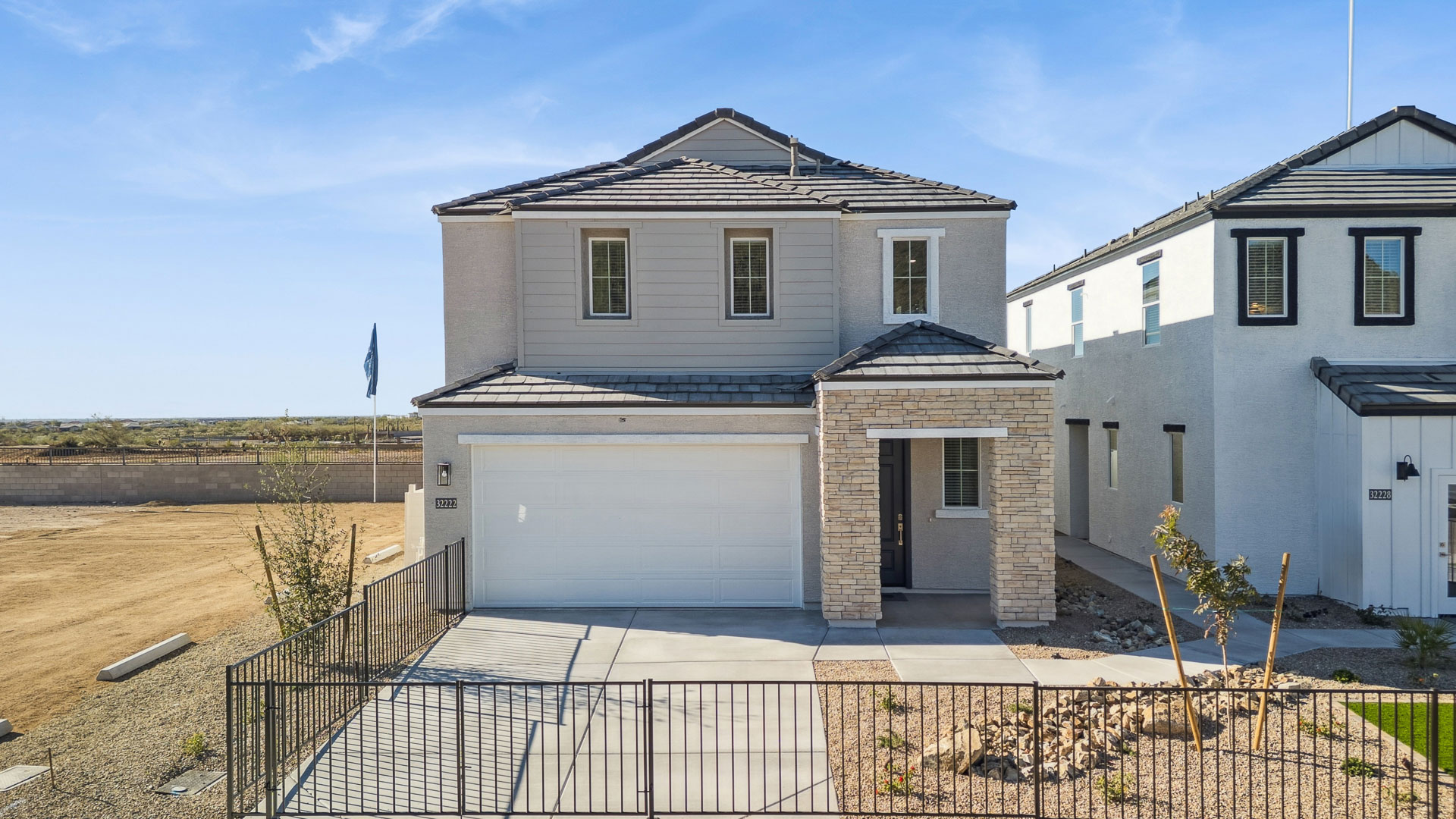 Exterior angle featuring garage, landscaped entry, and front façade of the Mirage Plan