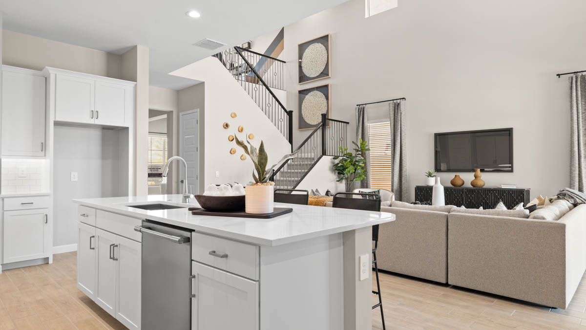 Bright and spacious kitchen with quartz countertops, stainless steel appliances, and an island with bar seating.